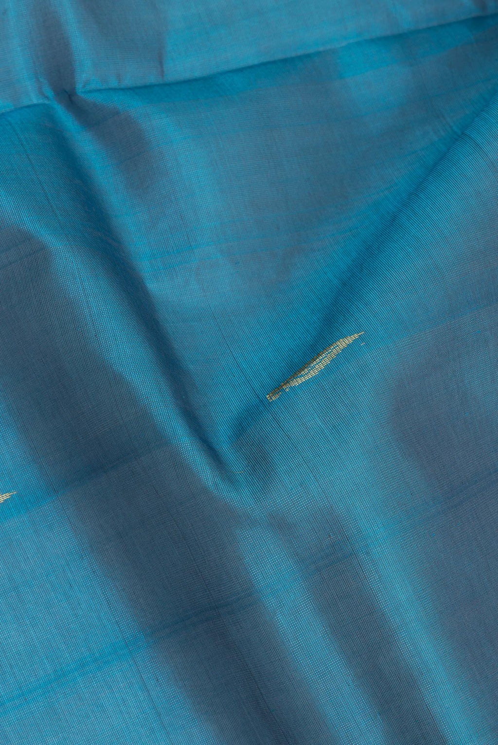 Close up of Sky Blue Silk Cotton Saree with Zari Butta on the body and Zari Border.  displaying folds