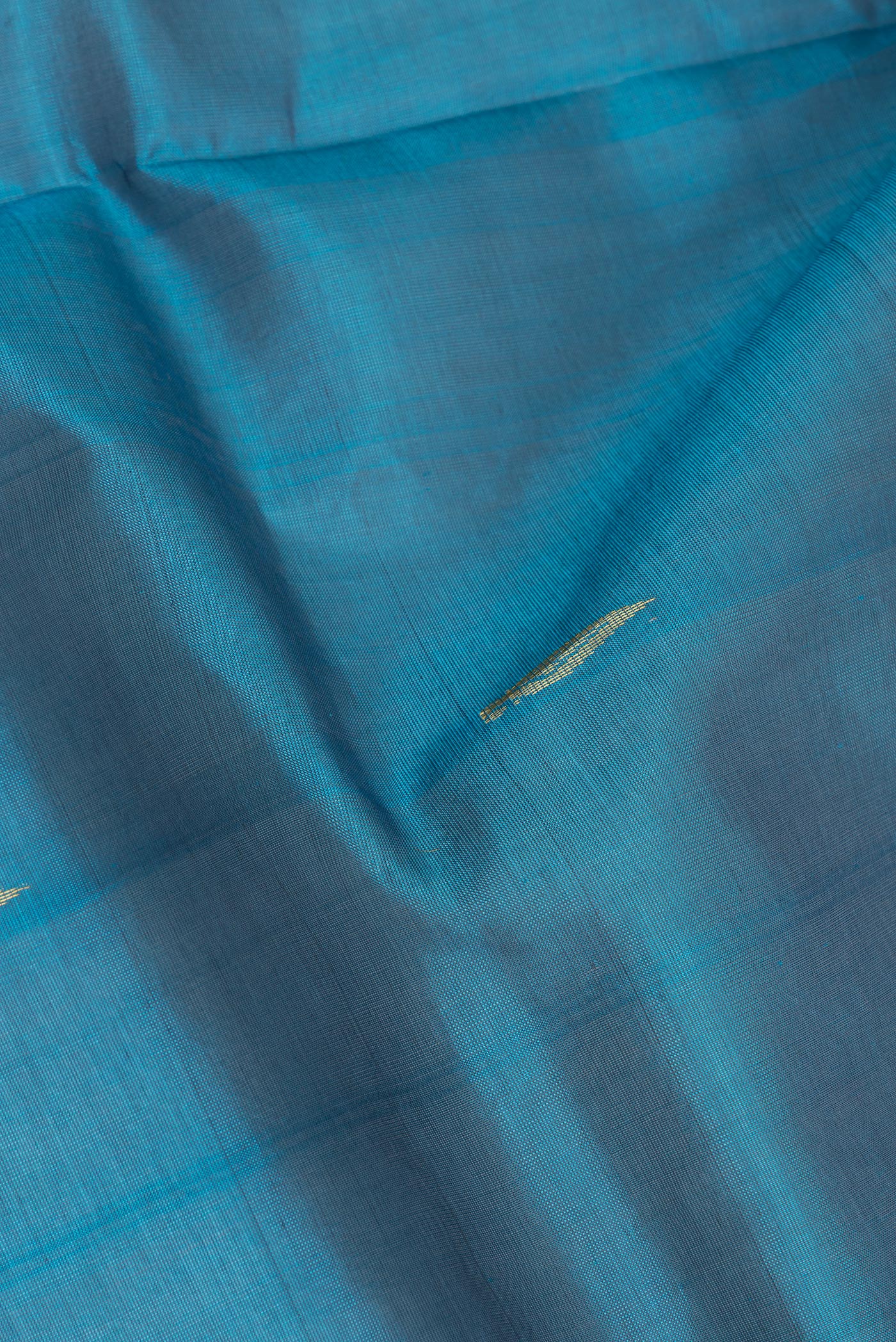 Close up of Sky Blue Silk Cotton Saree with Zari Butta on the body and Zari Border.  displaying folds