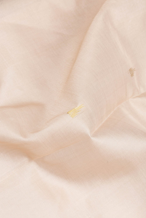 Close up of Beige Silk Cotton Saree with Zari Butta on the body and Zari Border.  displaying folds