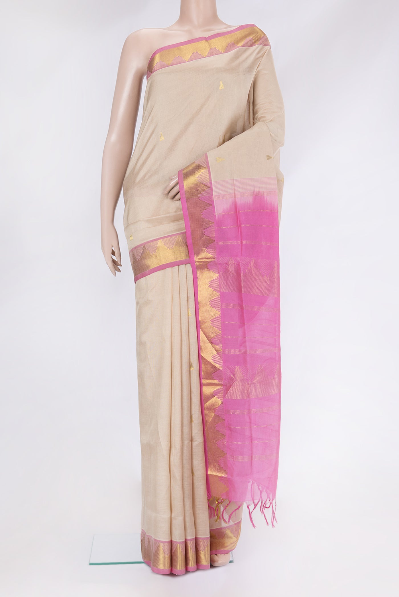 Beige Silk Cotton Saree with Zari Butta on the body and Zari Border.  displayed on a mannequin