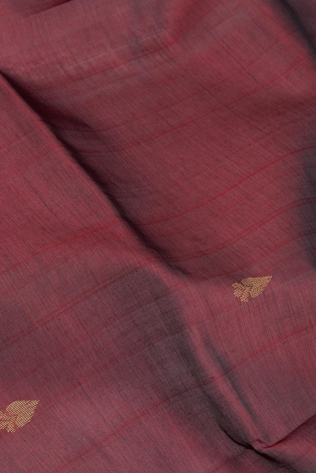 Close up of Maroon Silk Cotton Saree with Zari Butta on the body and Zari Border.  displaying folds