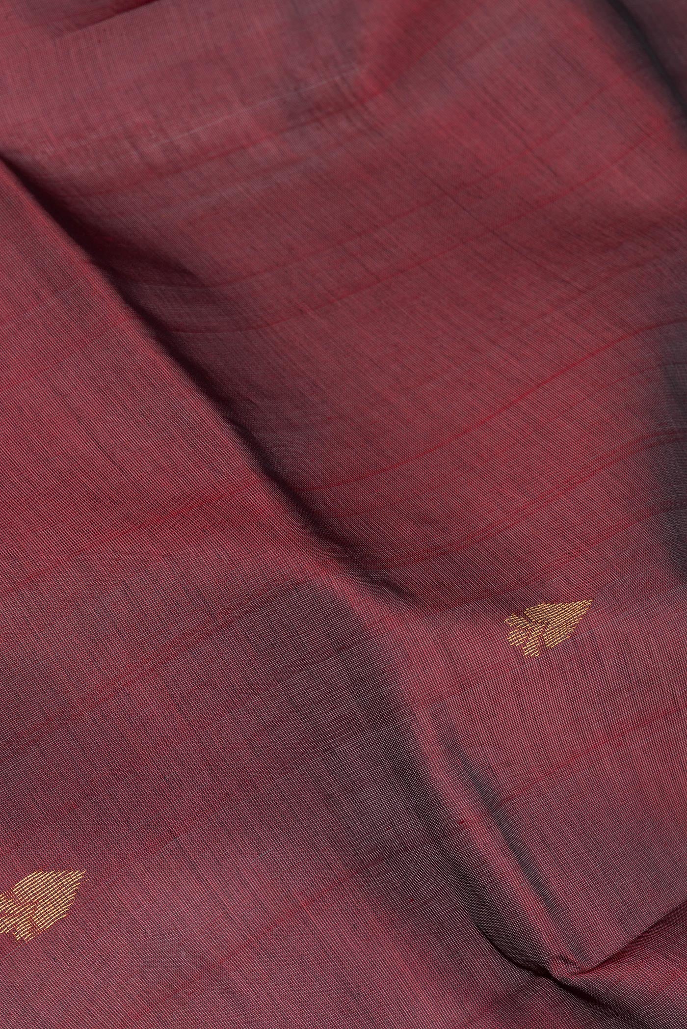 Close up of Maroon Silk Cotton Saree with Zari Butta on the body and Zari Border.  displaying folds