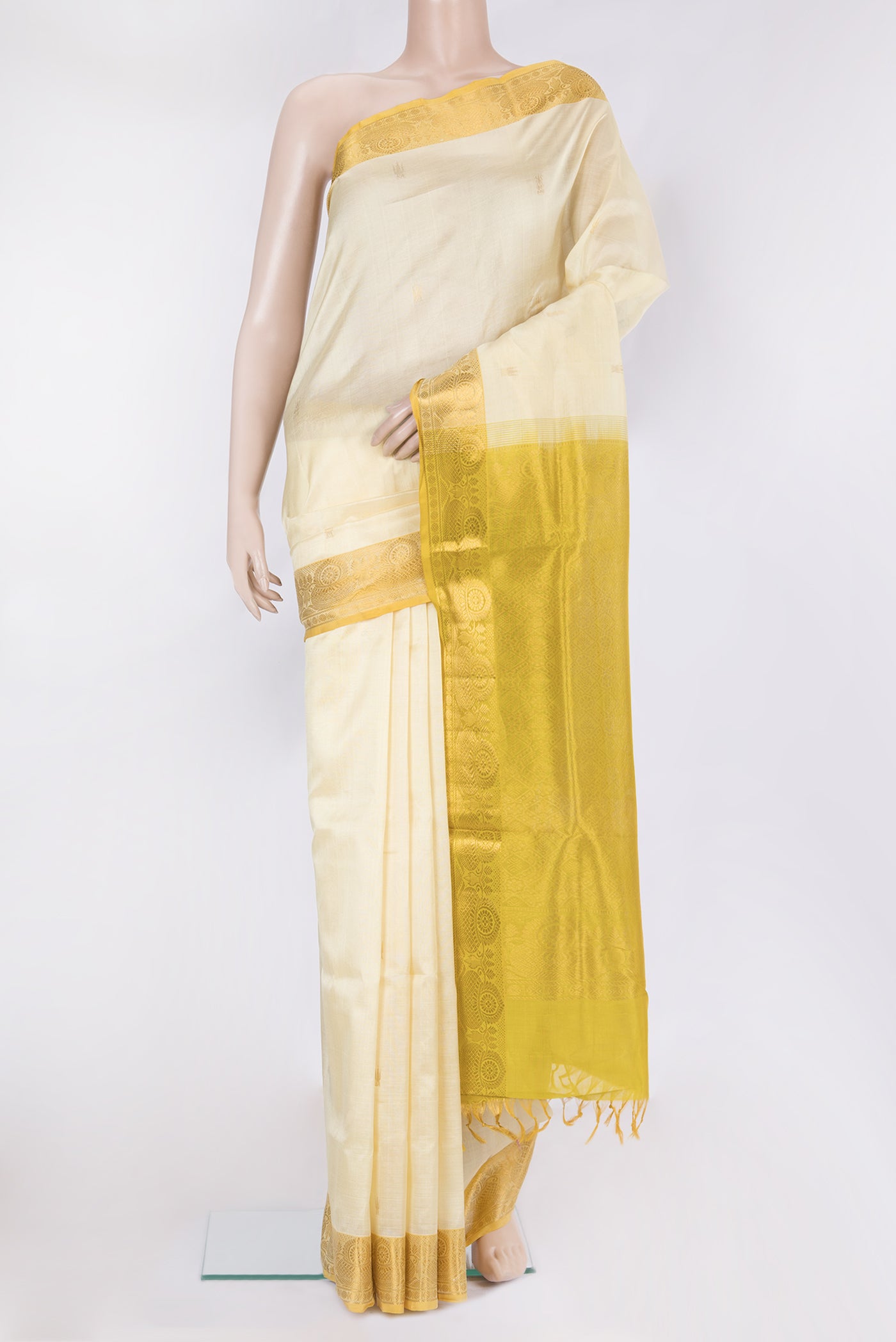 Cream Silk Cotton Saree with Zari Butta on the body and Zari Border.  displayed on a mannequin
