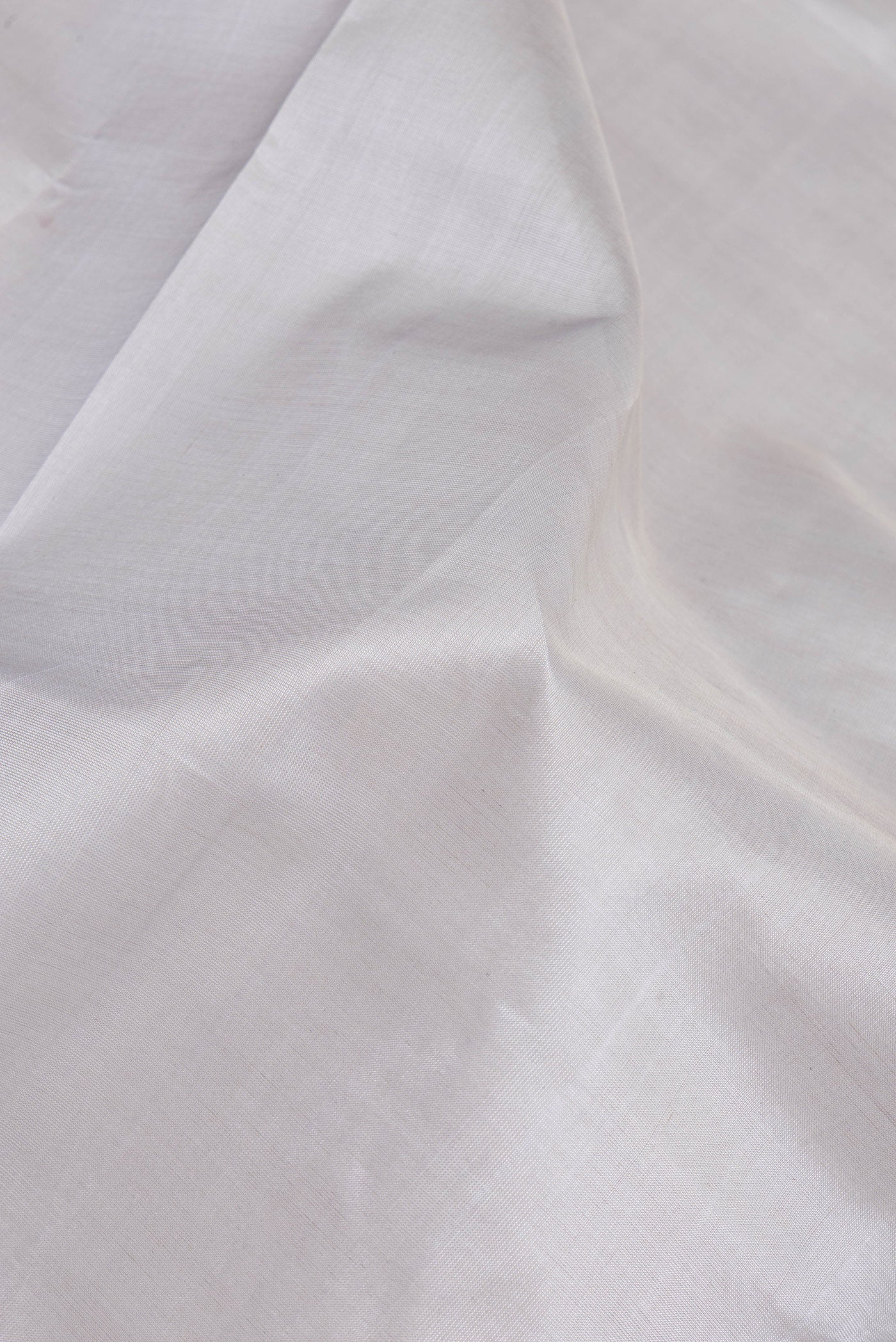 Close up of Grey Silk Cotton Saree with Plain Body and Zari Border.  displaying folds
