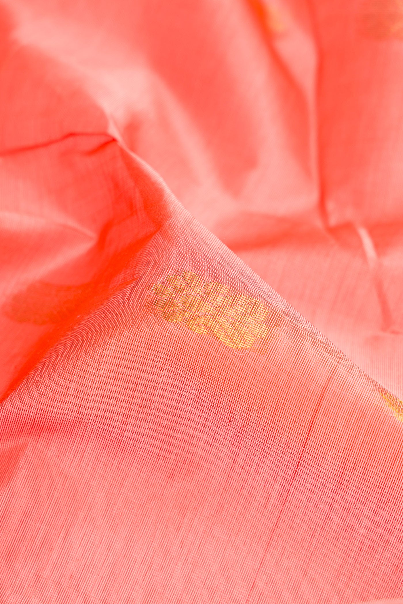 Close up of Golden Peach Dual Tone Silk Cotton Saree with Zari Butta on the body and Zari Border.  displaying folds