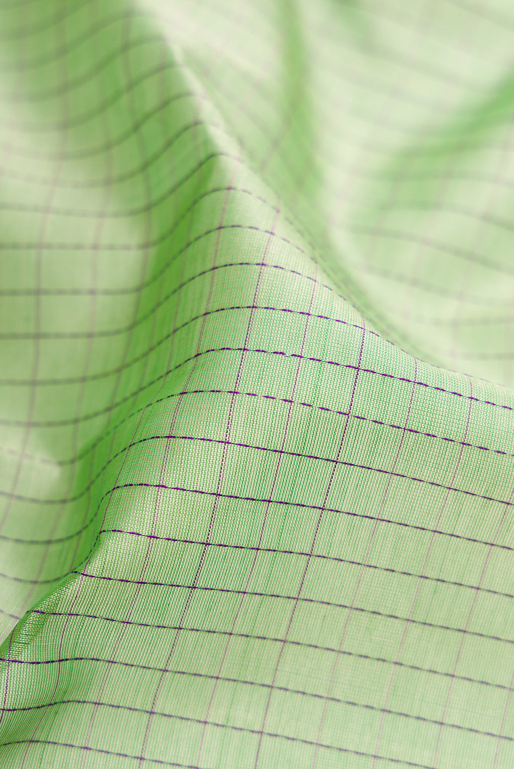 Close up of Pista Green Dual Tone Silk Cotton Saree with Checked design on the body and Zari Border.  displaying folds