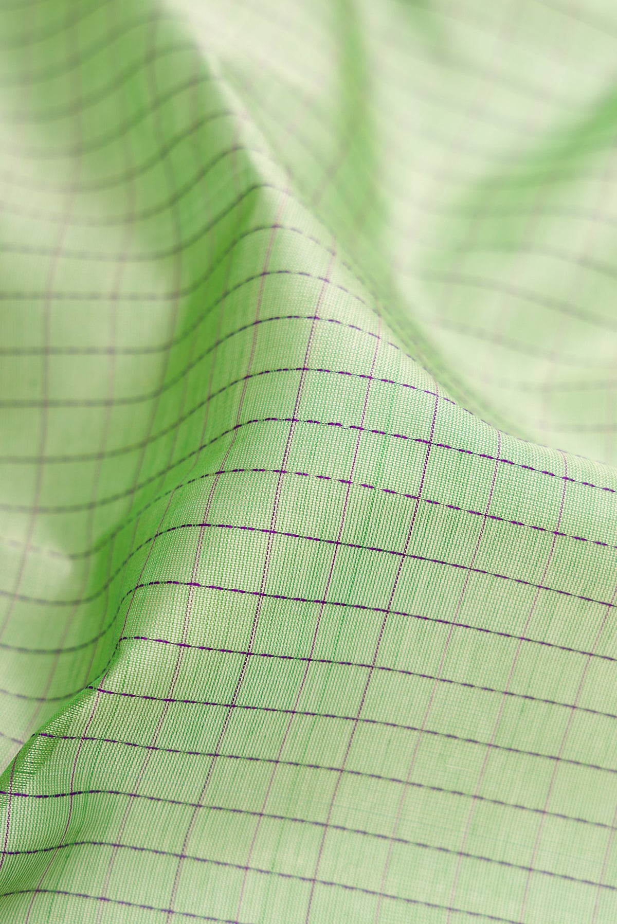 Close up of Pista Green Dual Tone Silk Cotton Saree with Checked design on the body and Zari Border.  displaying folds