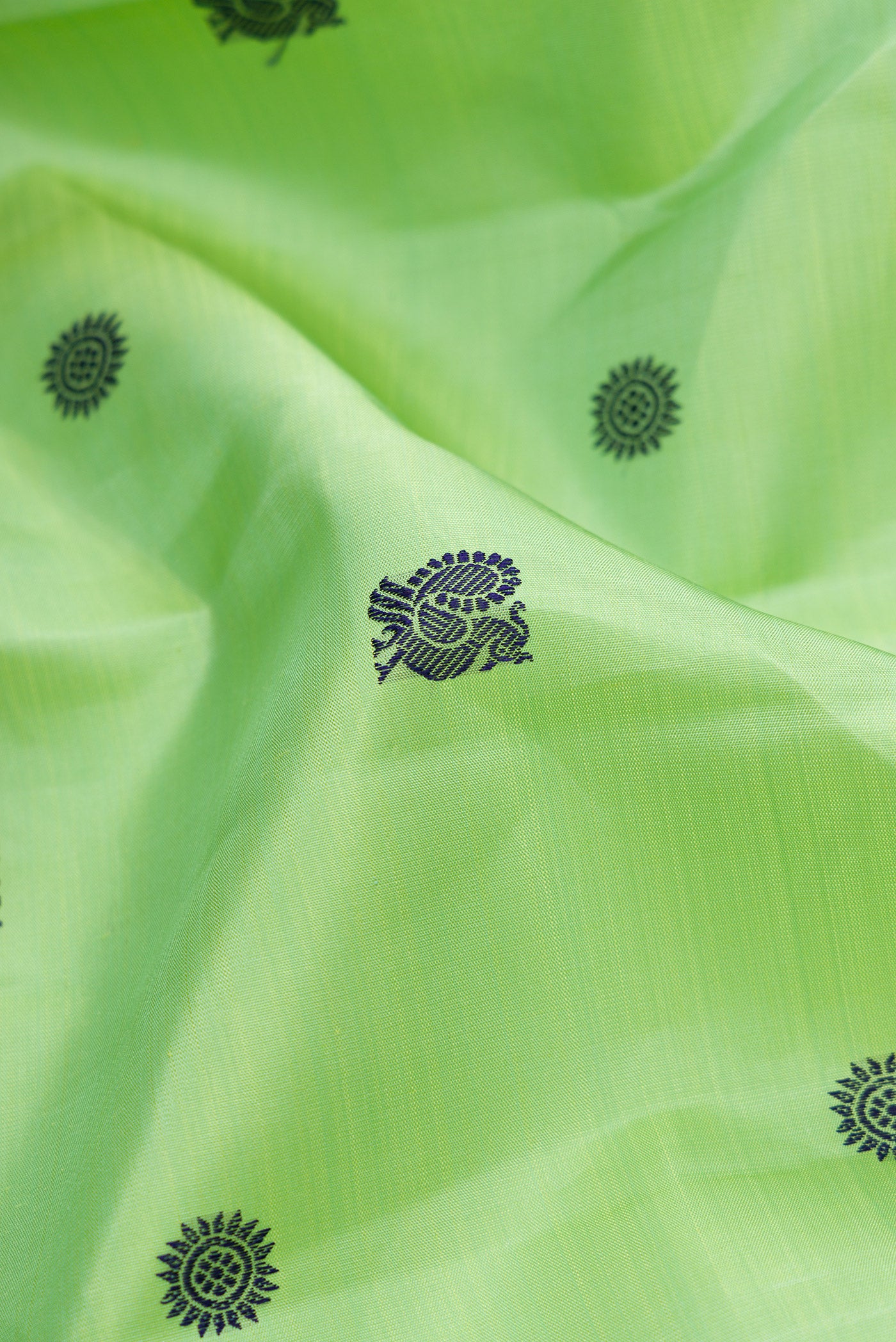 Close up of Pure Silk Pure Zari Green Dual Tone Kanchipuram Saree with Thread Butta on the body and Zari And Thread Border.  displaying folds