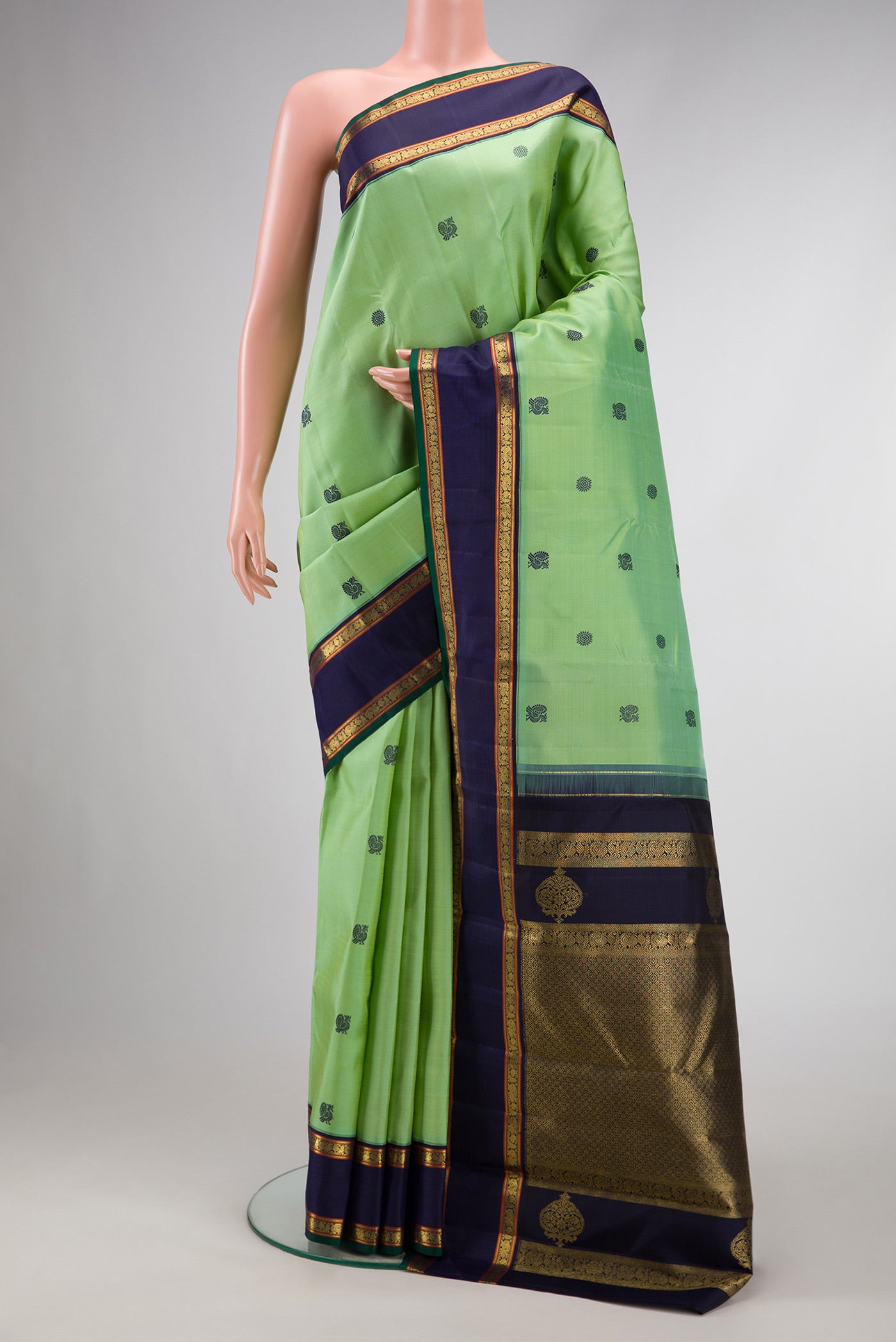 Pure Silk Pure Zari Green Dual Tone Kanchipuram Saree with Thread Butta on the body and Zari And Thread Border.  displayed on a mannequin