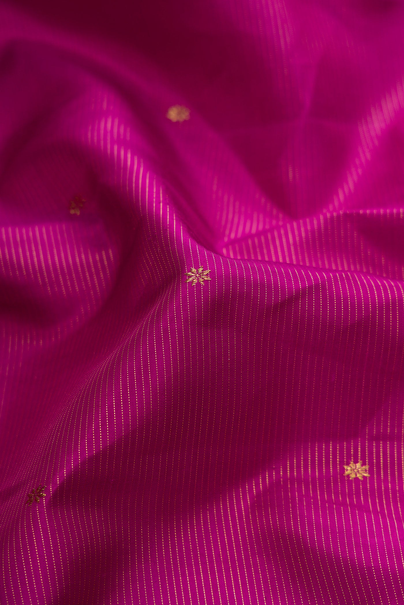 Close up of Pure Silk Pure Zari Purple Dual Tone Kanchipuram Saree with Zari Butta on the body and Zari And Thread Border.  displaying folds