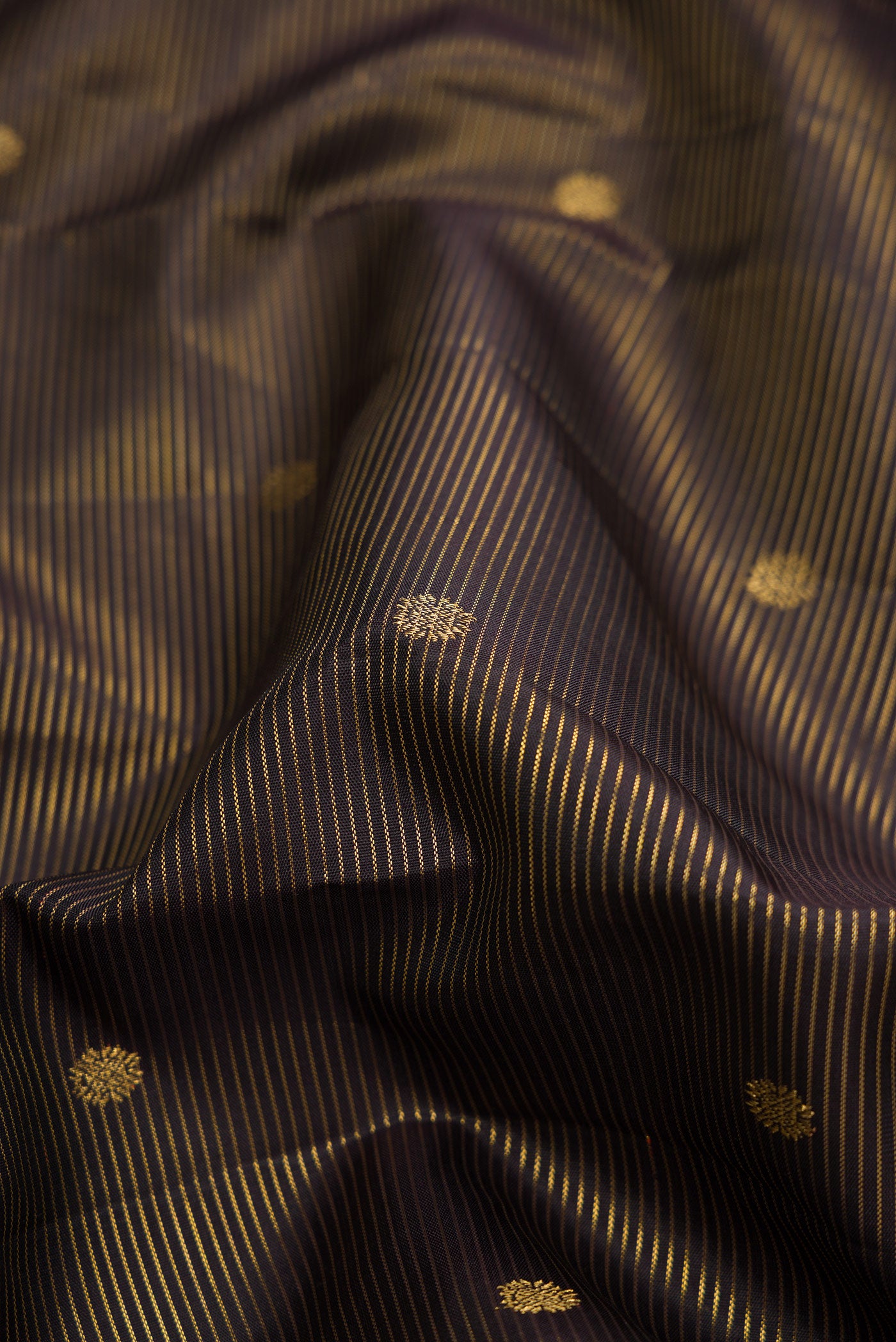 Close up of Black Dual Tone Kanchipuram Silk Saree with Stripes on the body and Zari Border.  displaying folds