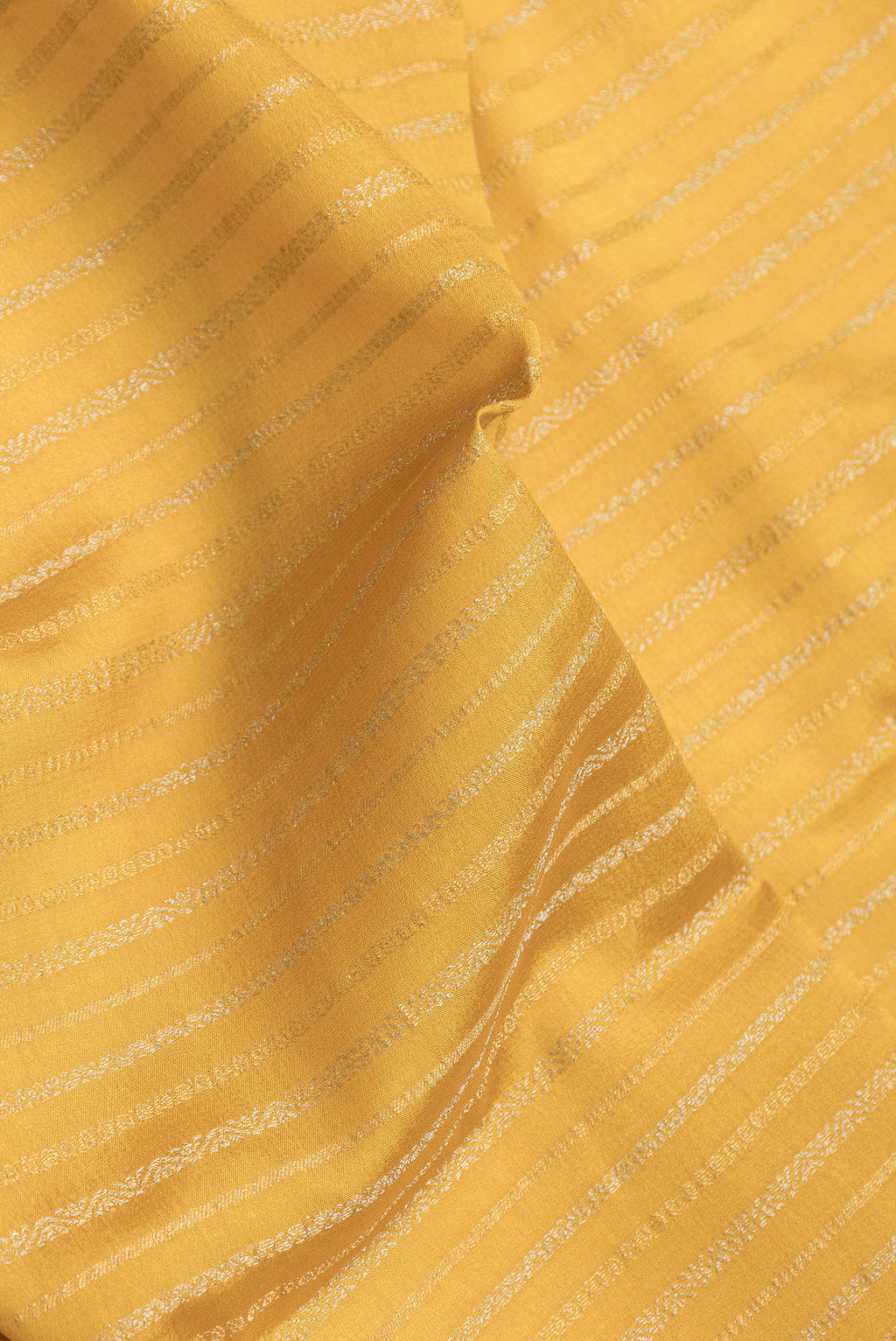 Close up of Mustard Dual Tone Banarasi Georgette Saree with Stripes on the body and Zari Border.  displaying folds