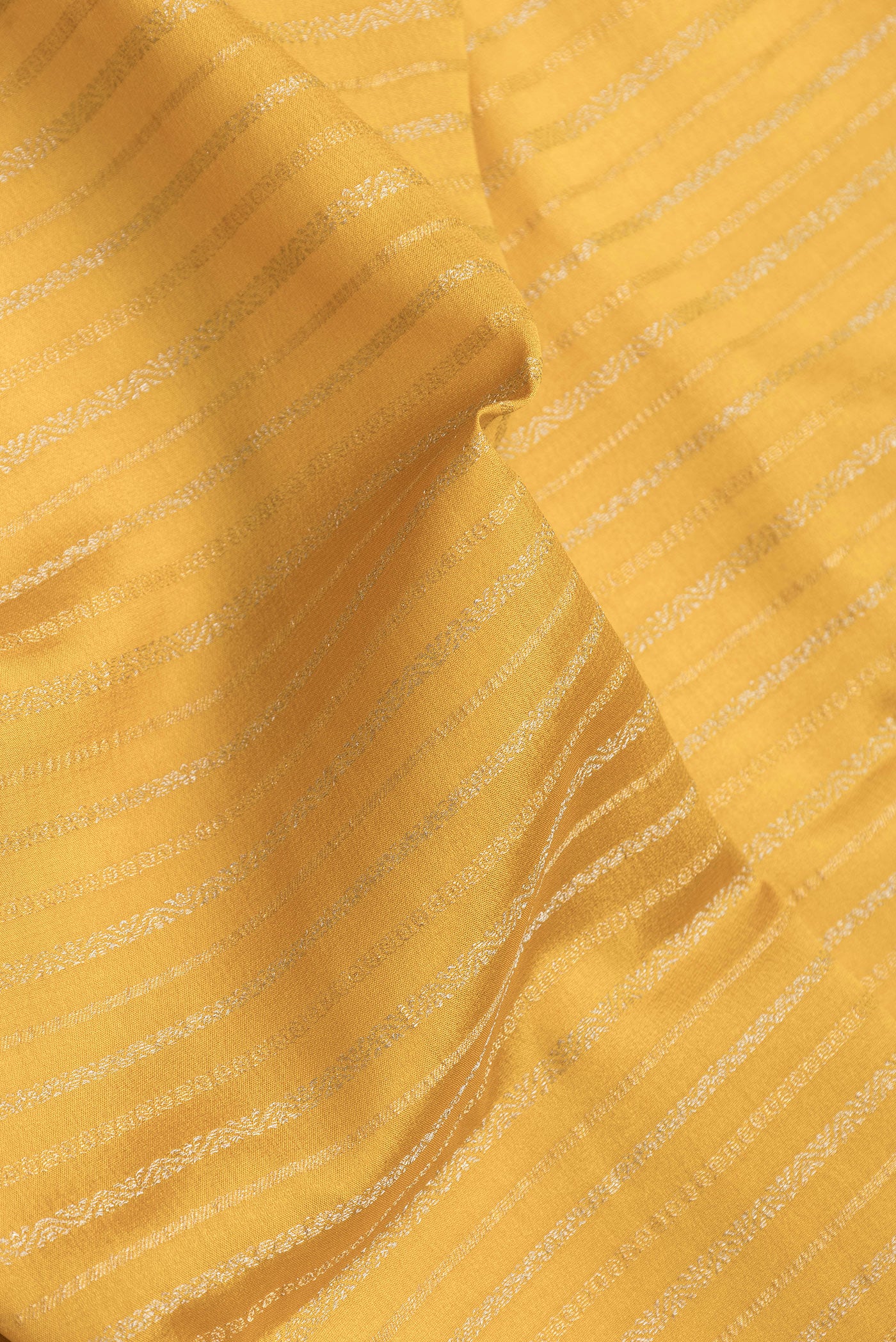 Close up of Mustard Dual Tone Banarasi Georgette Saree with Stripes on the body and Zari Border.  displaying folds