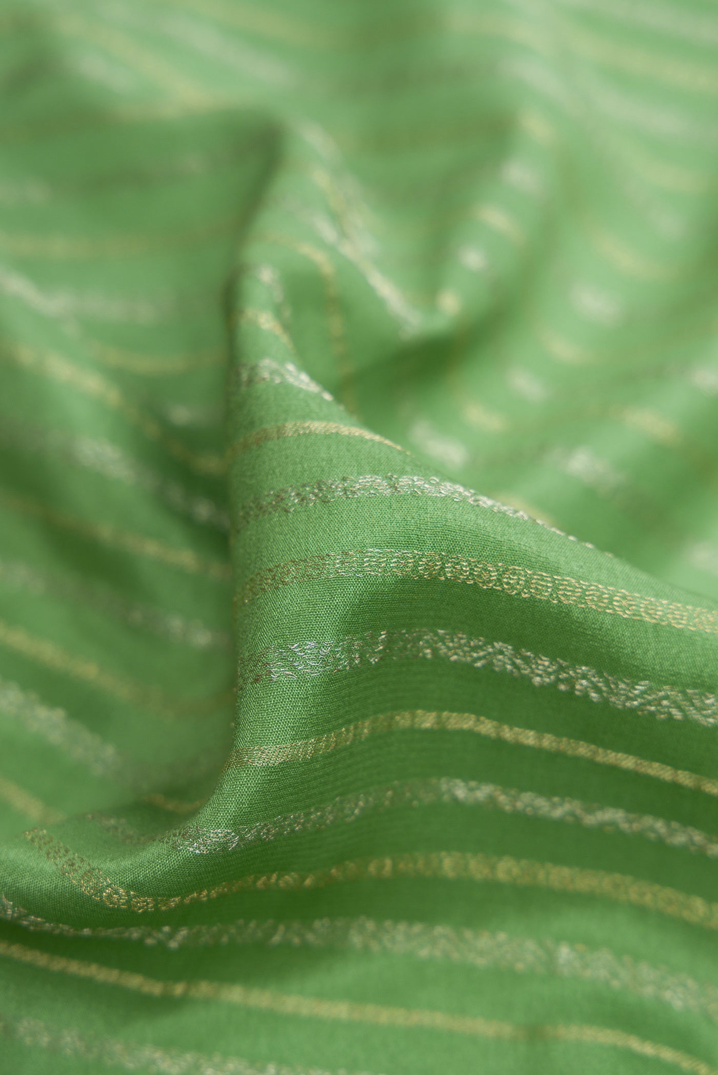 Close up of Pista Green Mysore Crepe Saree with Stripes on the body and Zari Border.  displaying folds