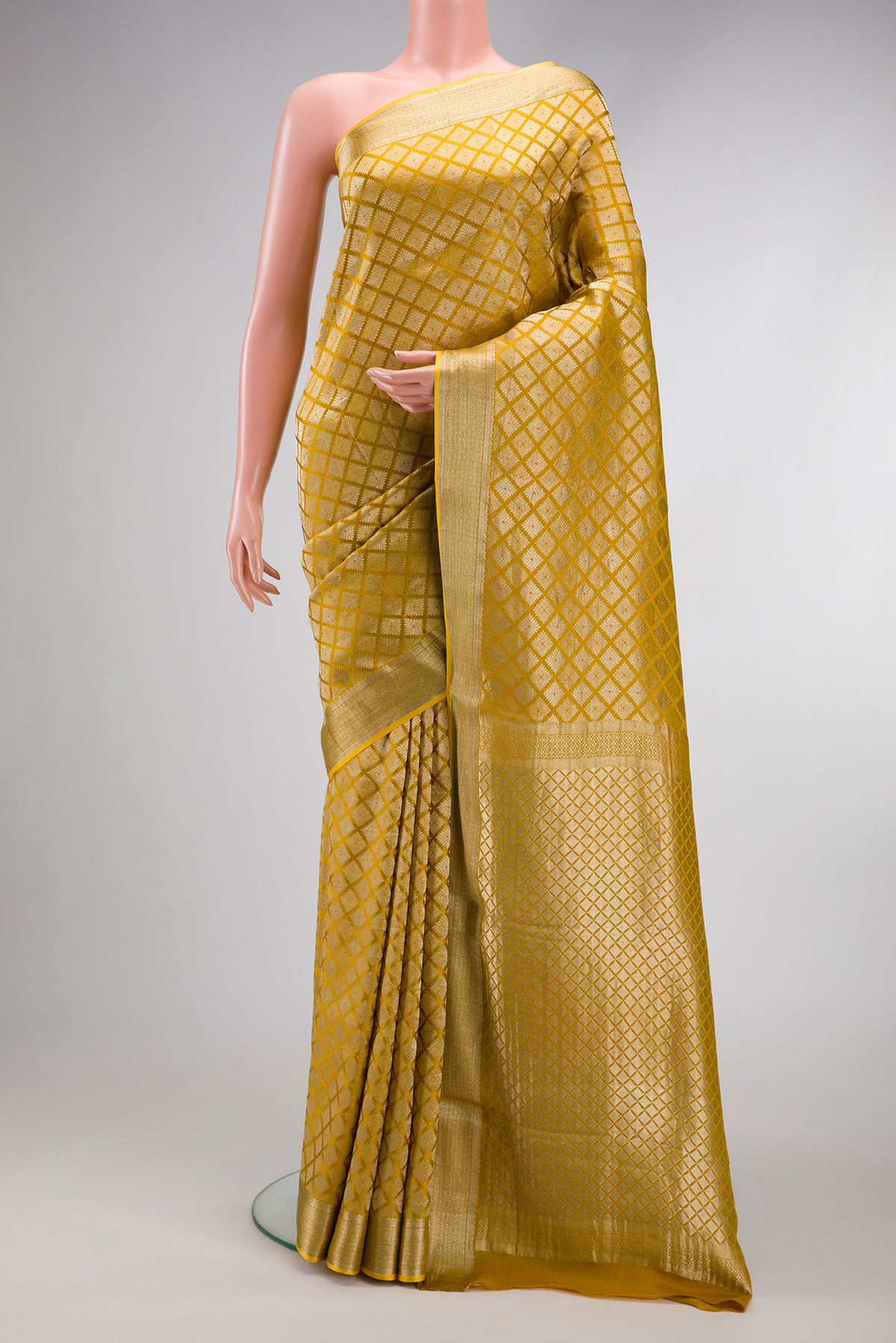 Mustard Dual Tone Mysore Crepe Saree with Zari Brocade on the body and Zari Border.  displayed on a mannequin