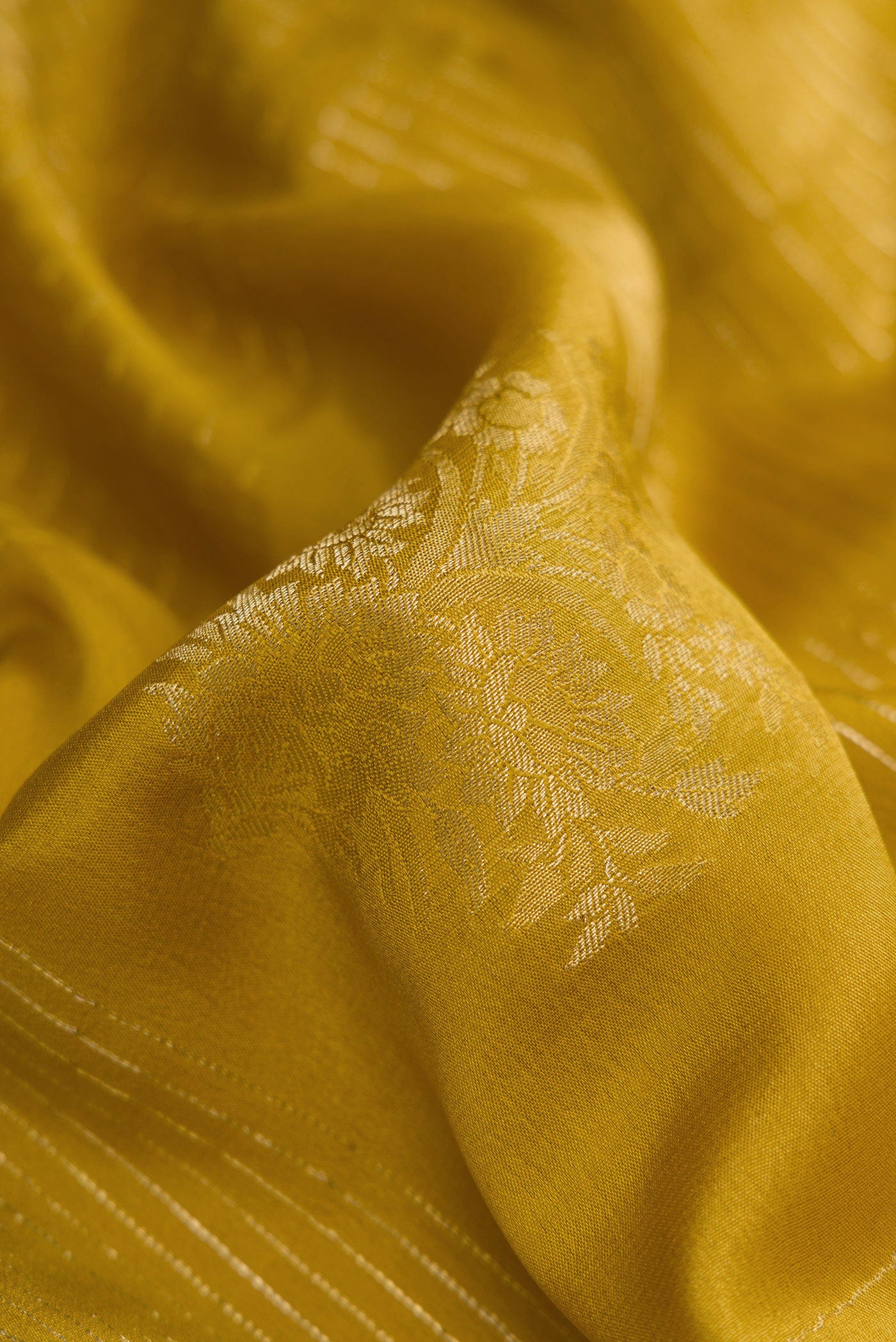 Close up of Mehandi Green Dual Tone Mysore Crepe Saree with Zari Butta on the body and Zari Border.  displaying folds