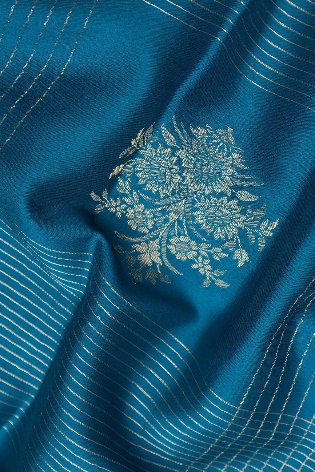 Close up of Peacock Blue Dual Tone Banarasi Georgette Saree with Checked design on the body and Zari And Thread Border.  displaying folds