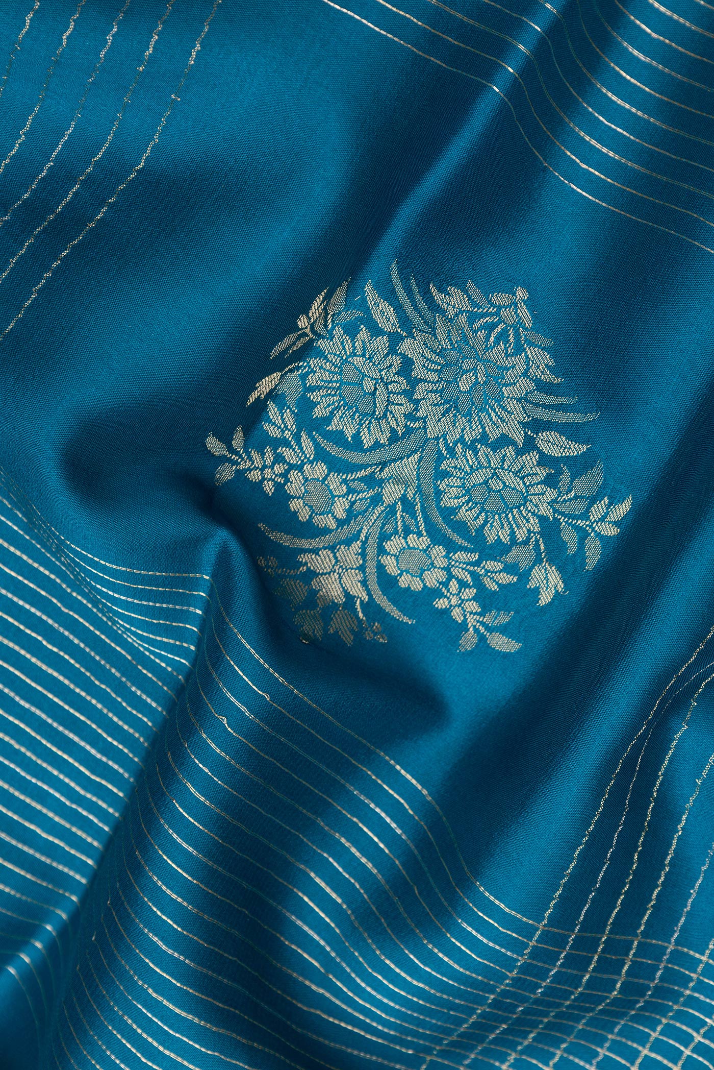 Close up of Peacock Blue Dual Tone Banarasi Georgette Saree with Checked design on the body and Zari And Thread Border.  displaying folds