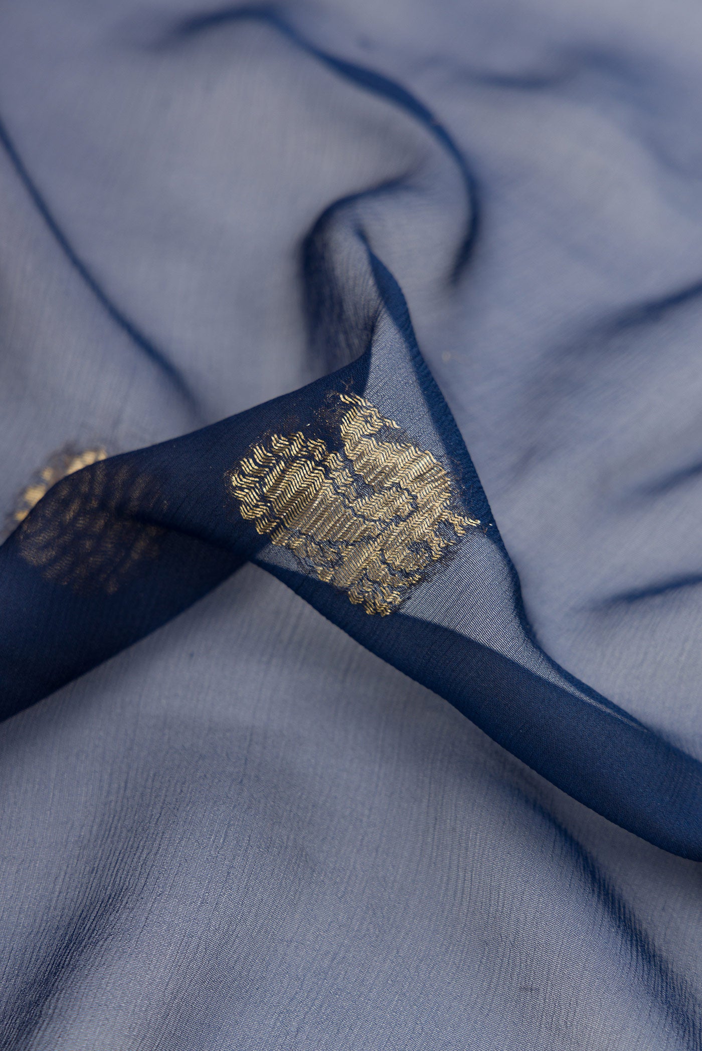 Close up of Navy Blue Mysore Georgette Saree with Zari Butta on the body and Zari Border.  displaying folds