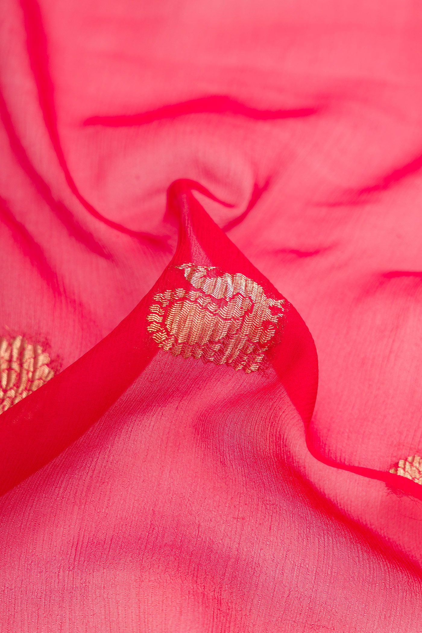Close up of Red Dual Tone Mysore Georgette Saree with Zari Butta on the body and Plain Border.  displaying folds