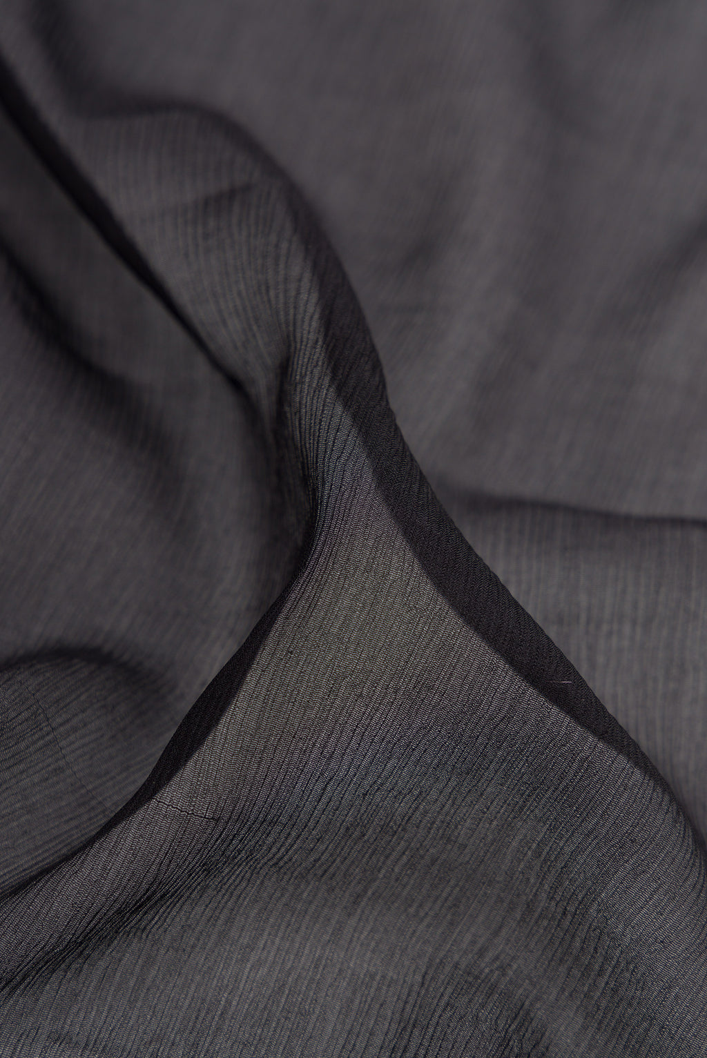 Close up of Black Mysore Chiffon Saree with Plain Body and Zari And Thread Border.  displaying folds