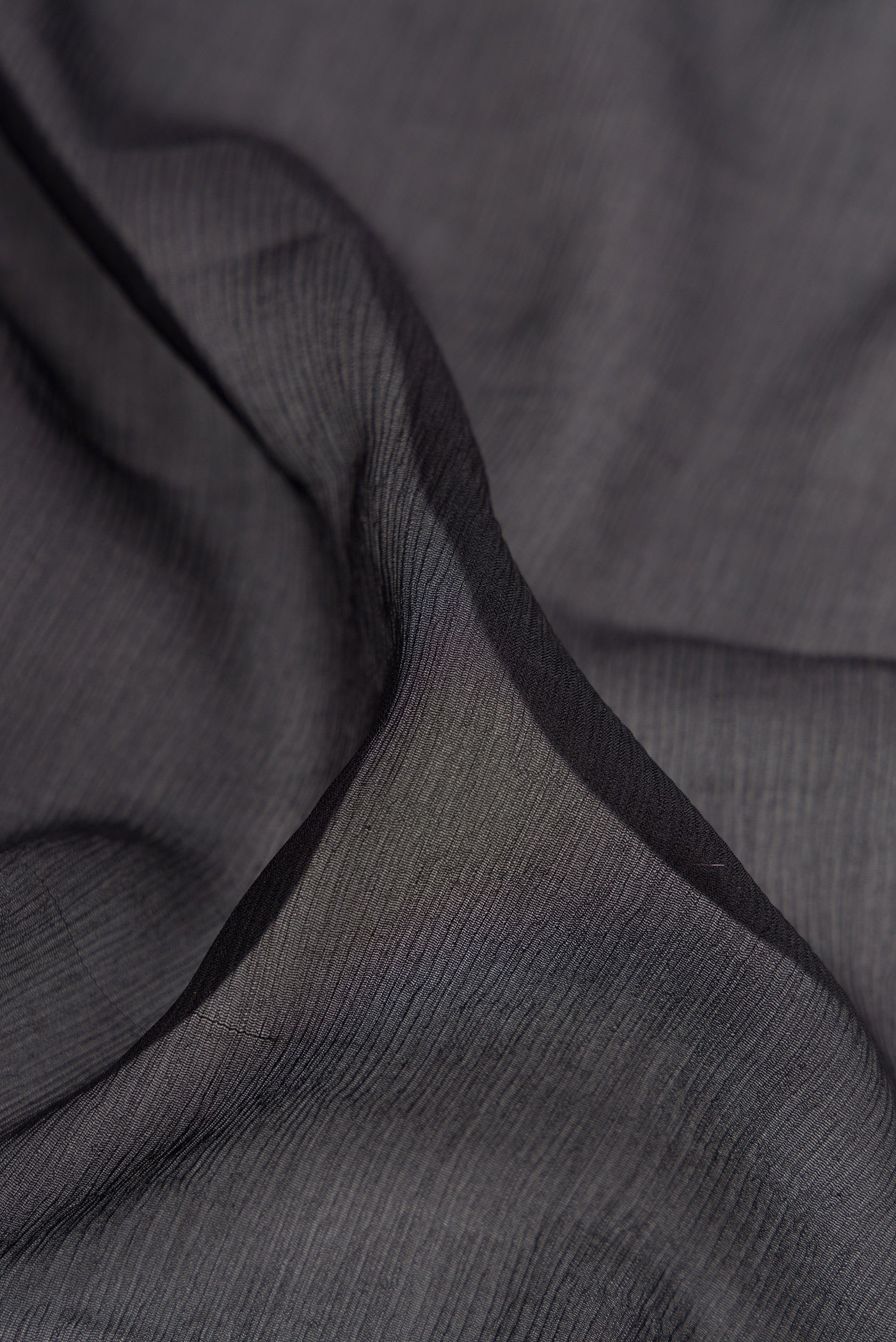 Close up of Black Mysore Chiffon Saree with Plain Body and Zari And Thread Border.  displaying folds