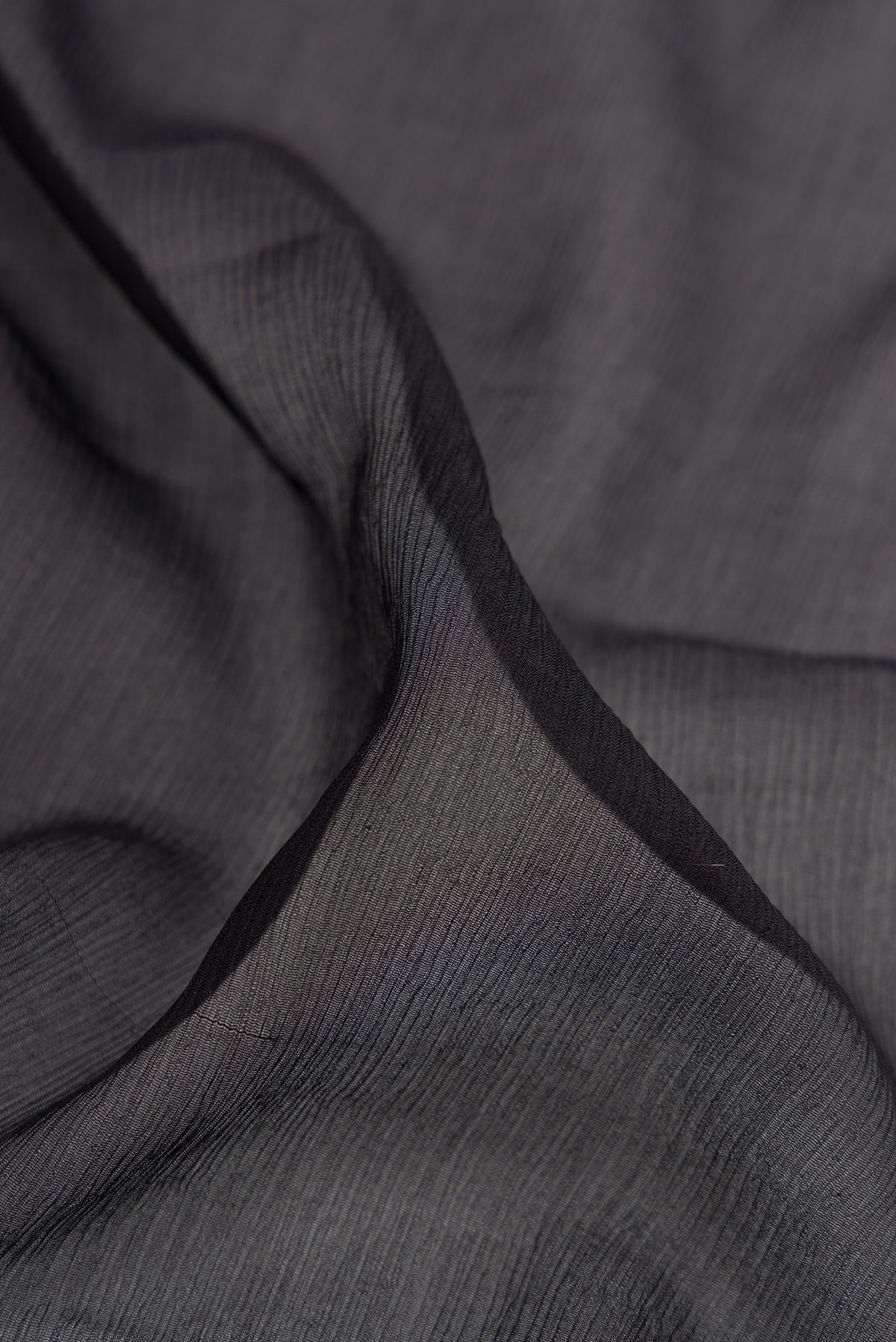 Close up of Black Mysore Chiffon Saree with Plain Body and Zari And Thread Border.  displaying folds