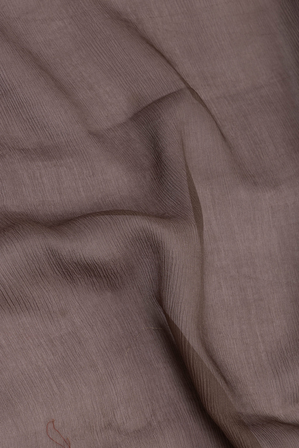 Close up of Brown Mysore Chiffon Saree with Plain Body and Zari Border.  displaying folds