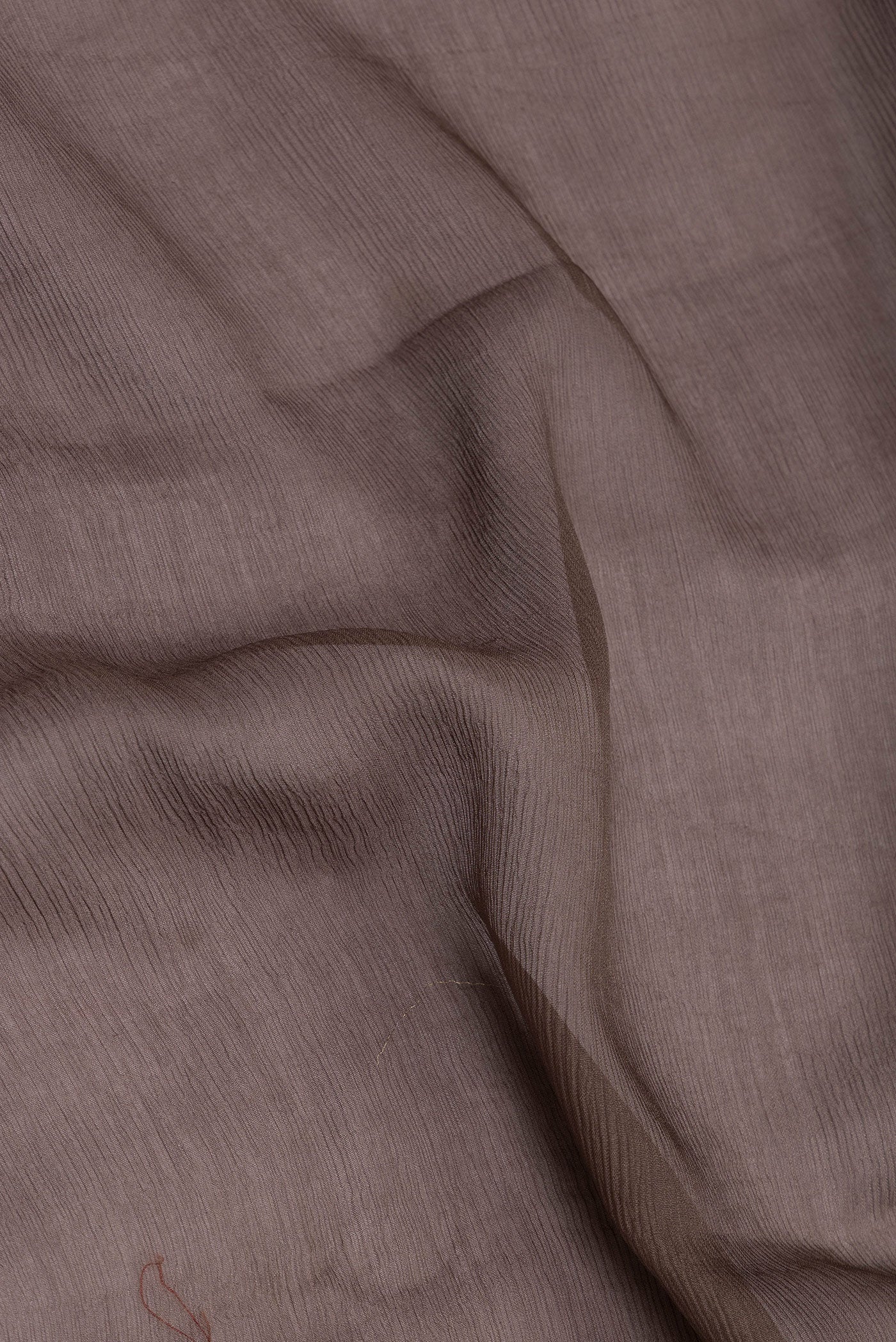 Close up of Brown Mysore Chiffon Saree with Plain Body and Zari Border.  displaying folds