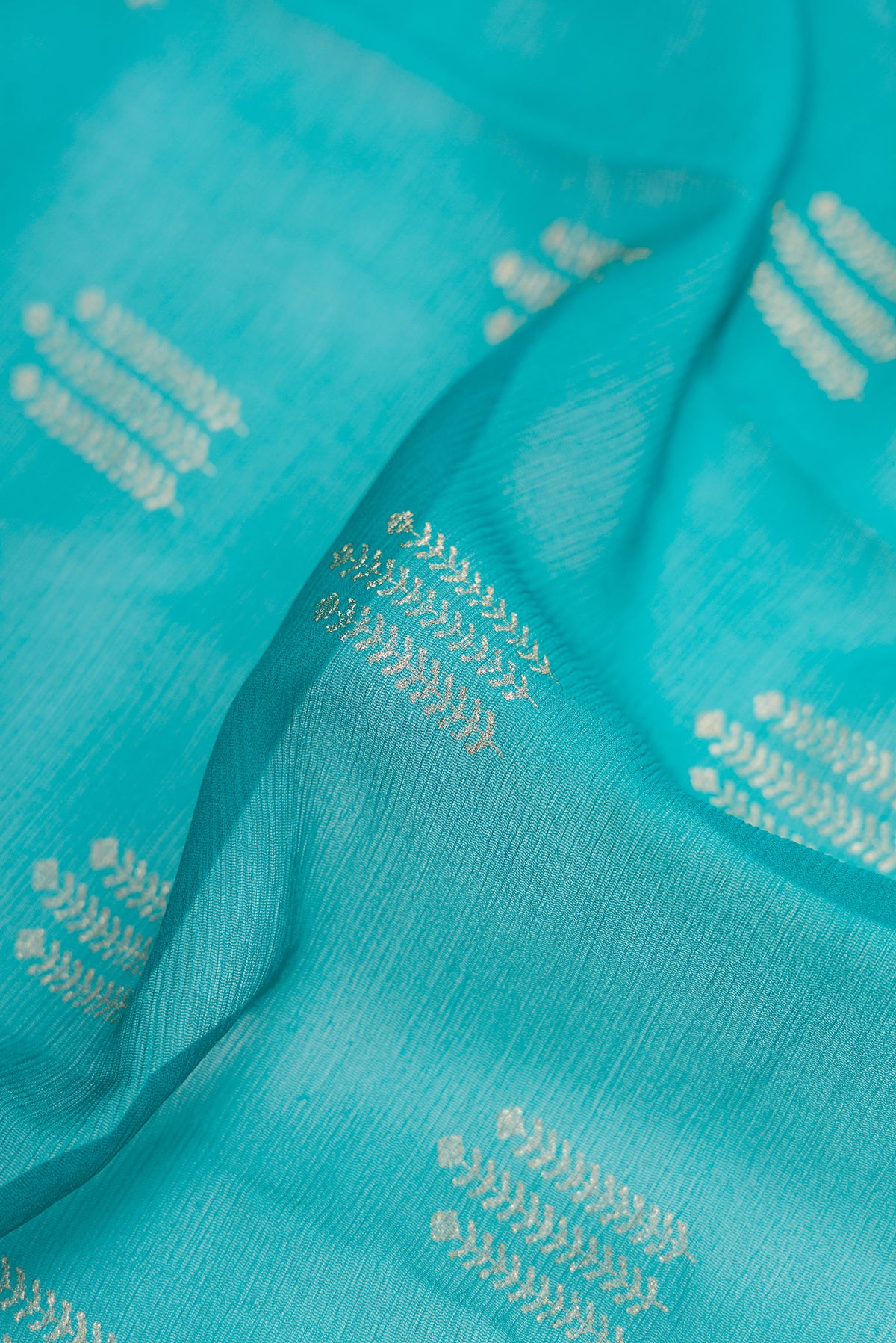 Close up of Peacock Blue Dual Tone Mysore Chiffon Saree with Zari Butta on the body and Zari Border.  displaying folds