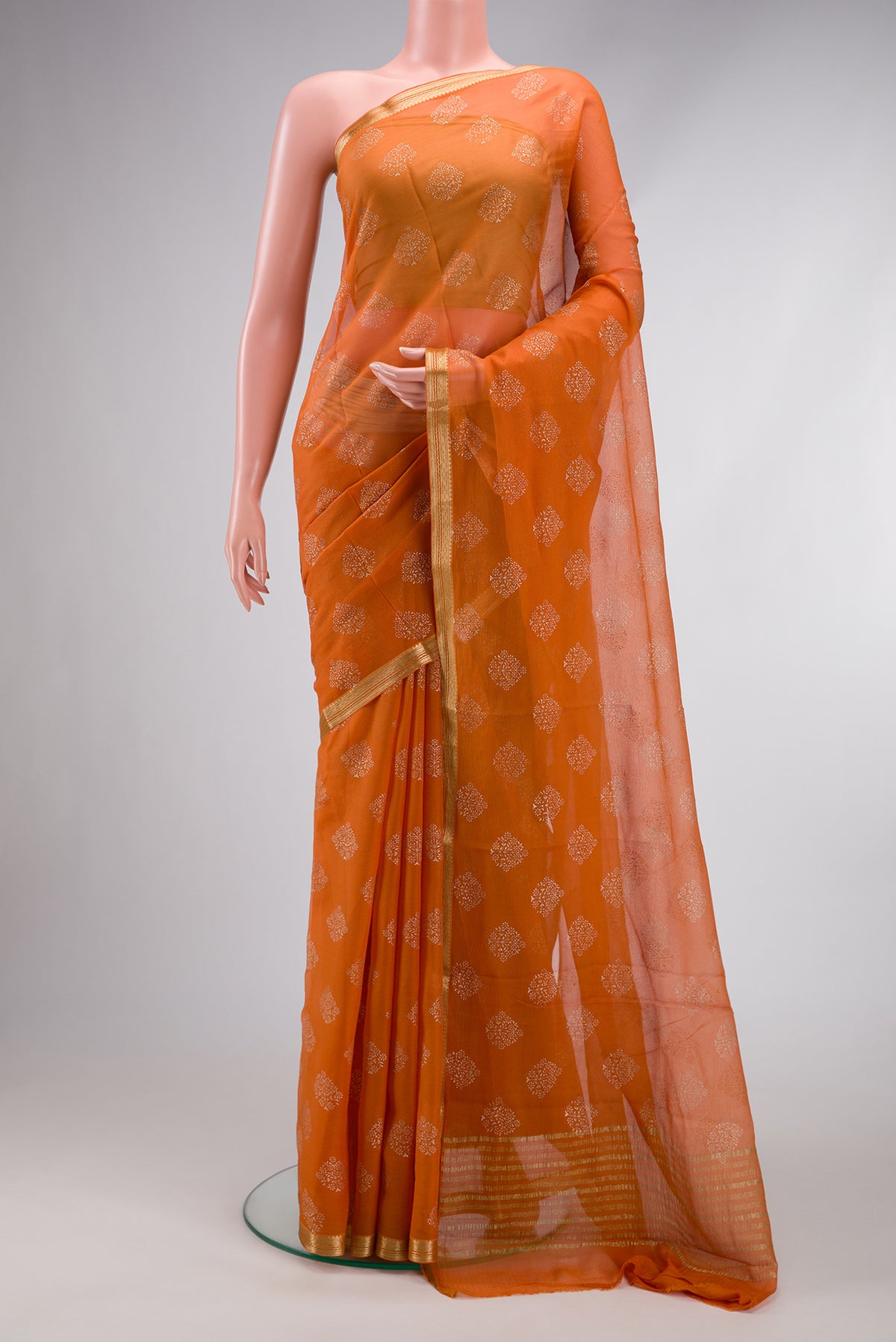 Mustard Mysore Chiffon Saree with Printed design on the body and Zari Border.  displayed on a mannequin