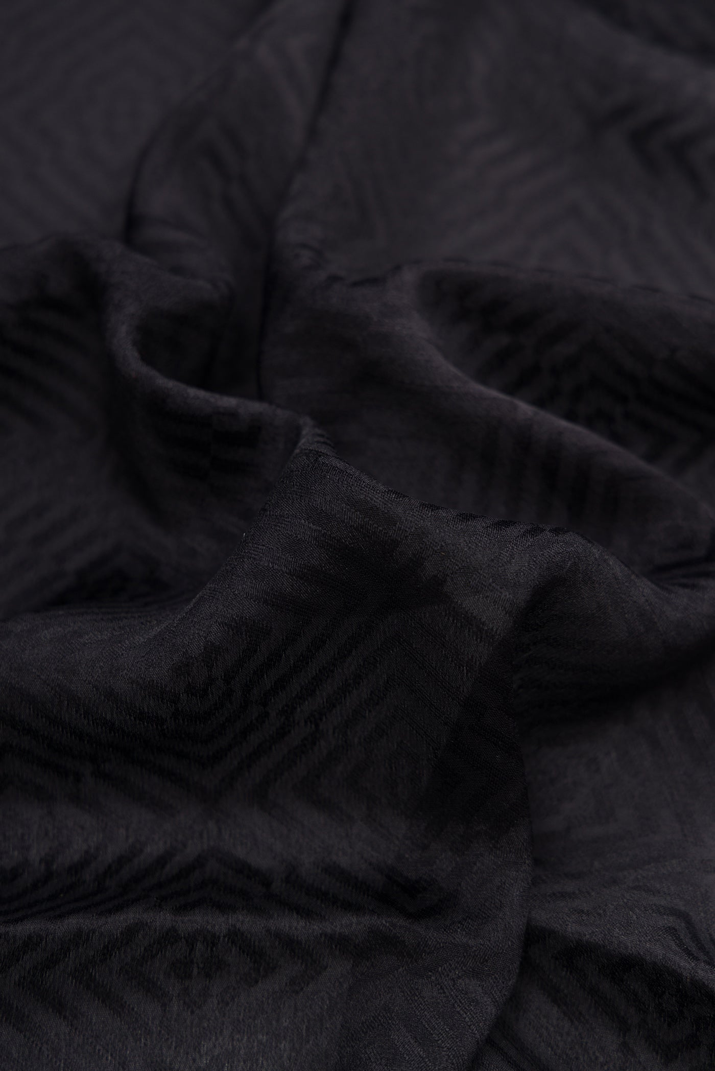 Close up of Black Dual Tone Mysore Georgette Saree with Jacquard design on the body and Zari Border.  displaying folds