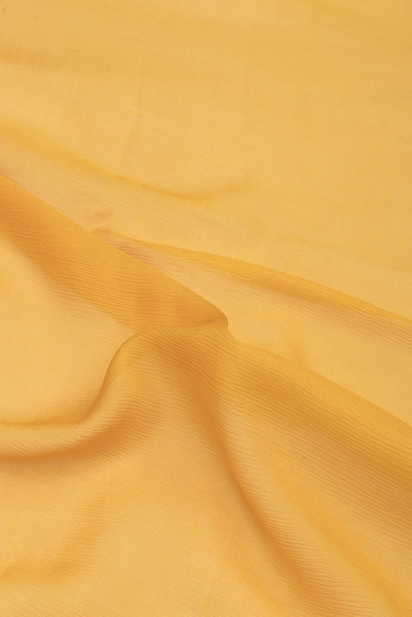 Close up of Mustard Mysore Chiffon Saree with Plain Body and Zari Border.  displaying folds