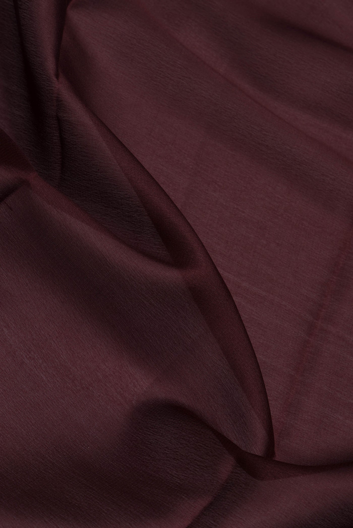 Close up of Coffee Brown Mysore Crepe Saree with Plain Body and Zari Border.  displaying folds