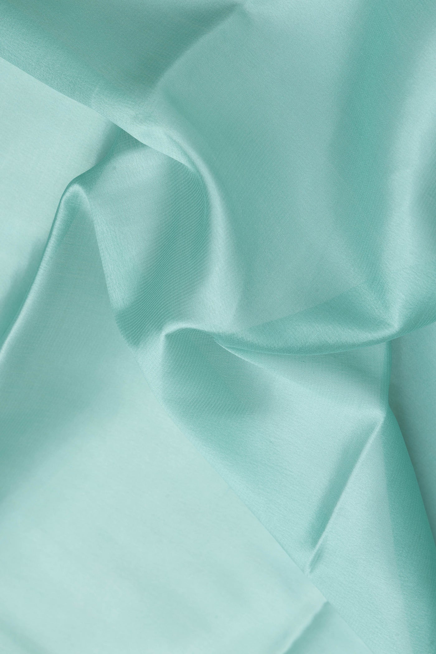 Close up of Sea Green Mysore Crepe Saree with Plain Body and Zari Border.  displaying folds