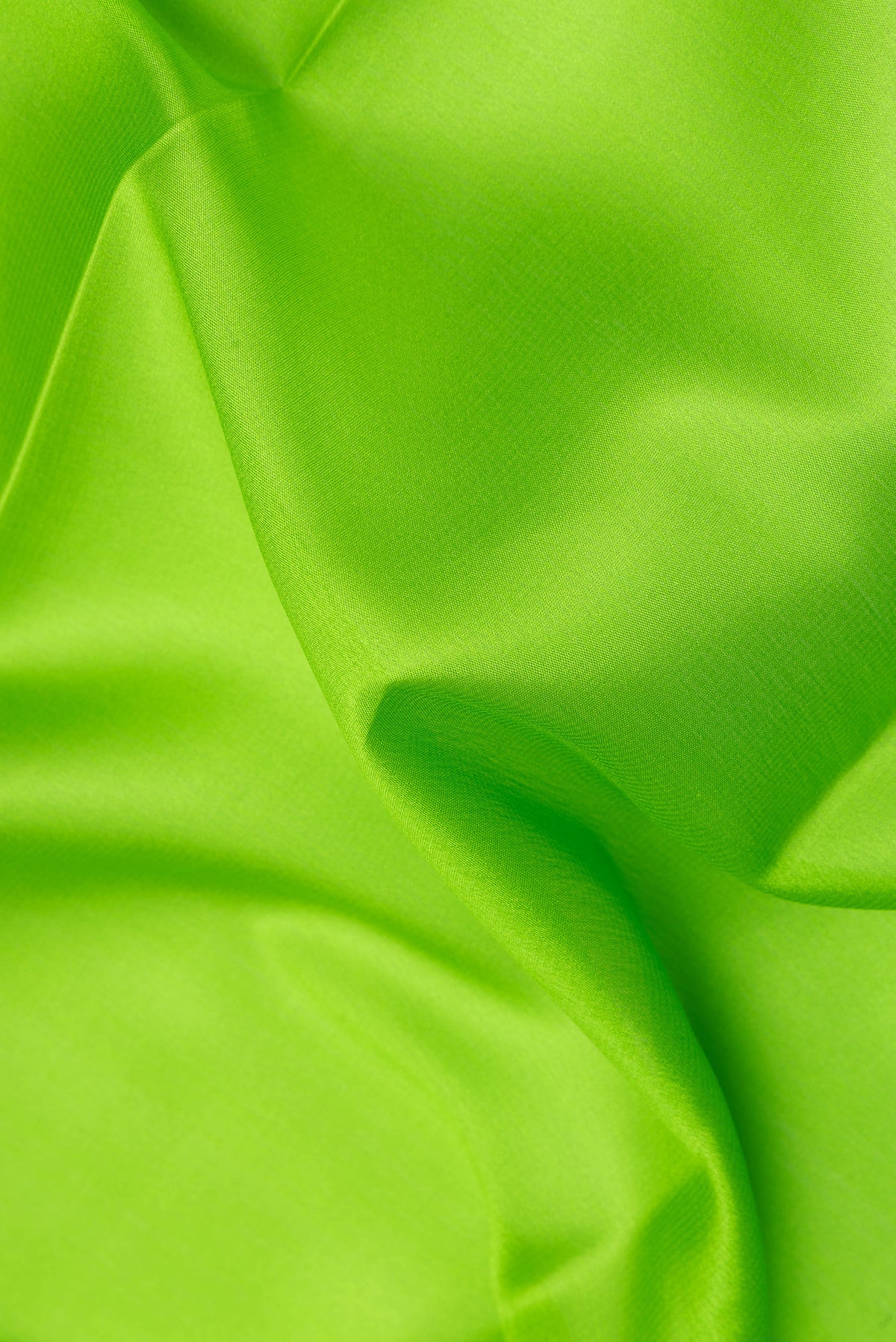 Close up of Parrot Green Mysore Crepe Saree with Plain Body and Zari Border.  displaying folds