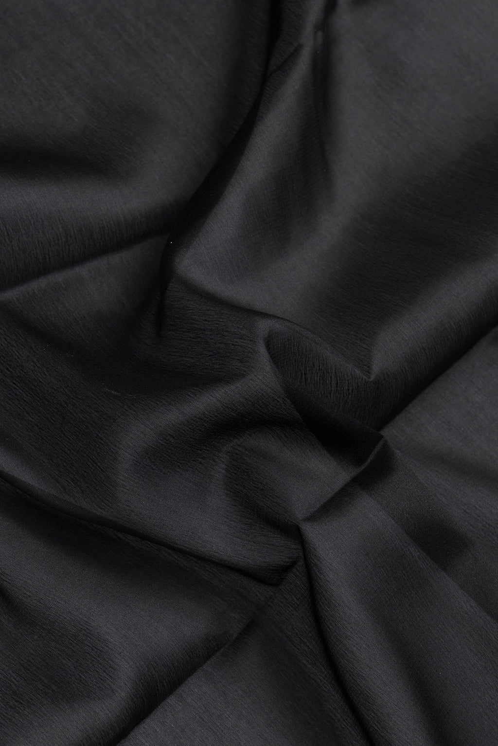Close up of Black Dual Tone Mysore Silk Saree with Plain Body and Zari Border.  displaying folds