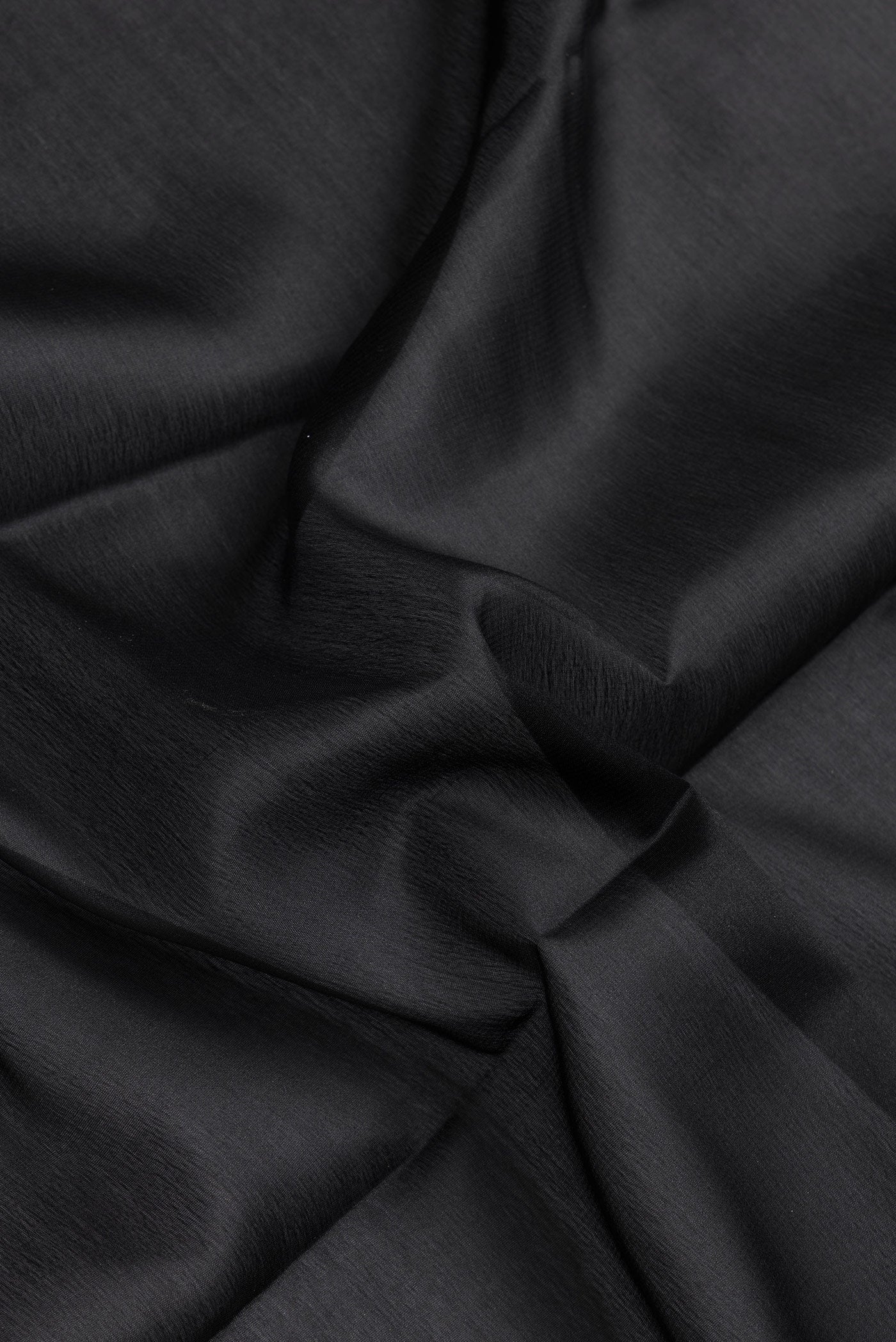 Close up of Black Dual Tone Mysore Silk Saree with Plain Body and Zari Border.  displaying folds