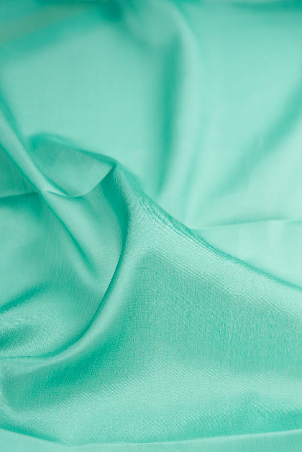 Close up of Sky Blue Mysore Crepe Saree with Plain Body and Zari Border.  displaying folds