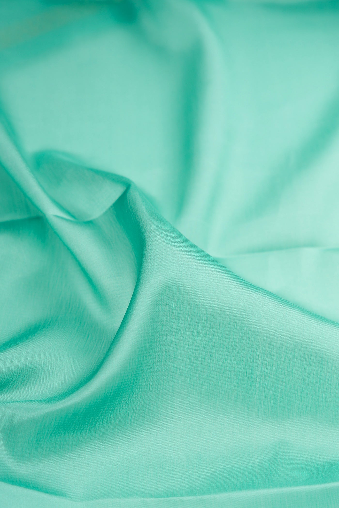 Close up of Sky Blue Mysore Crepe Saree with Plain Body and Zari Border.  displaying folds