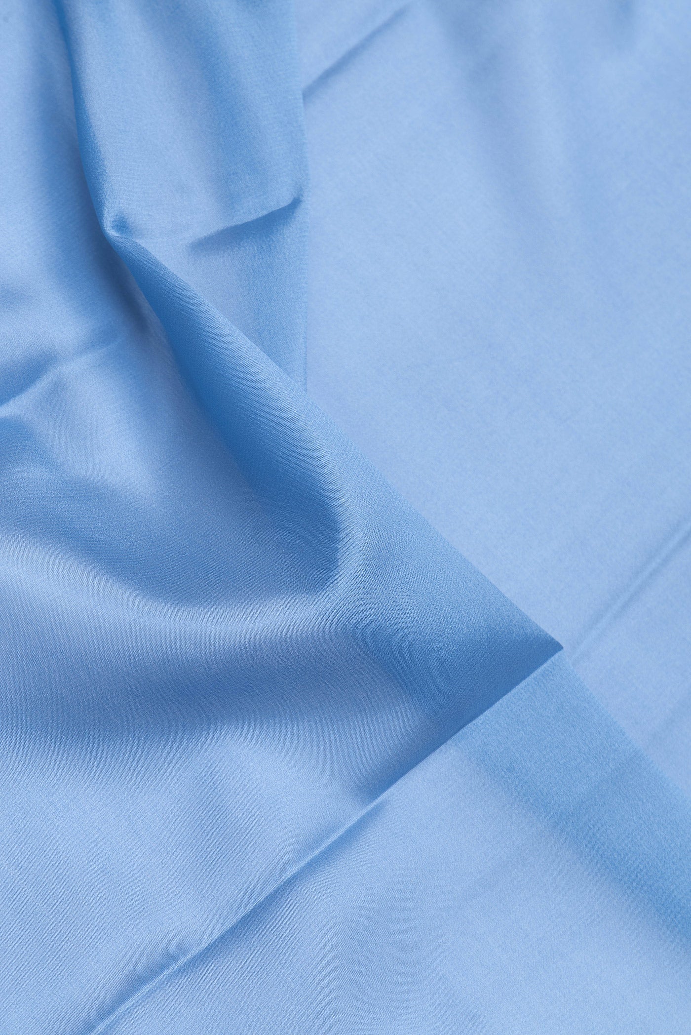 Close up of Sky Blue Dual Tone Mysore Crepe Saree with Plain Body and Zari Border.  displaying folds