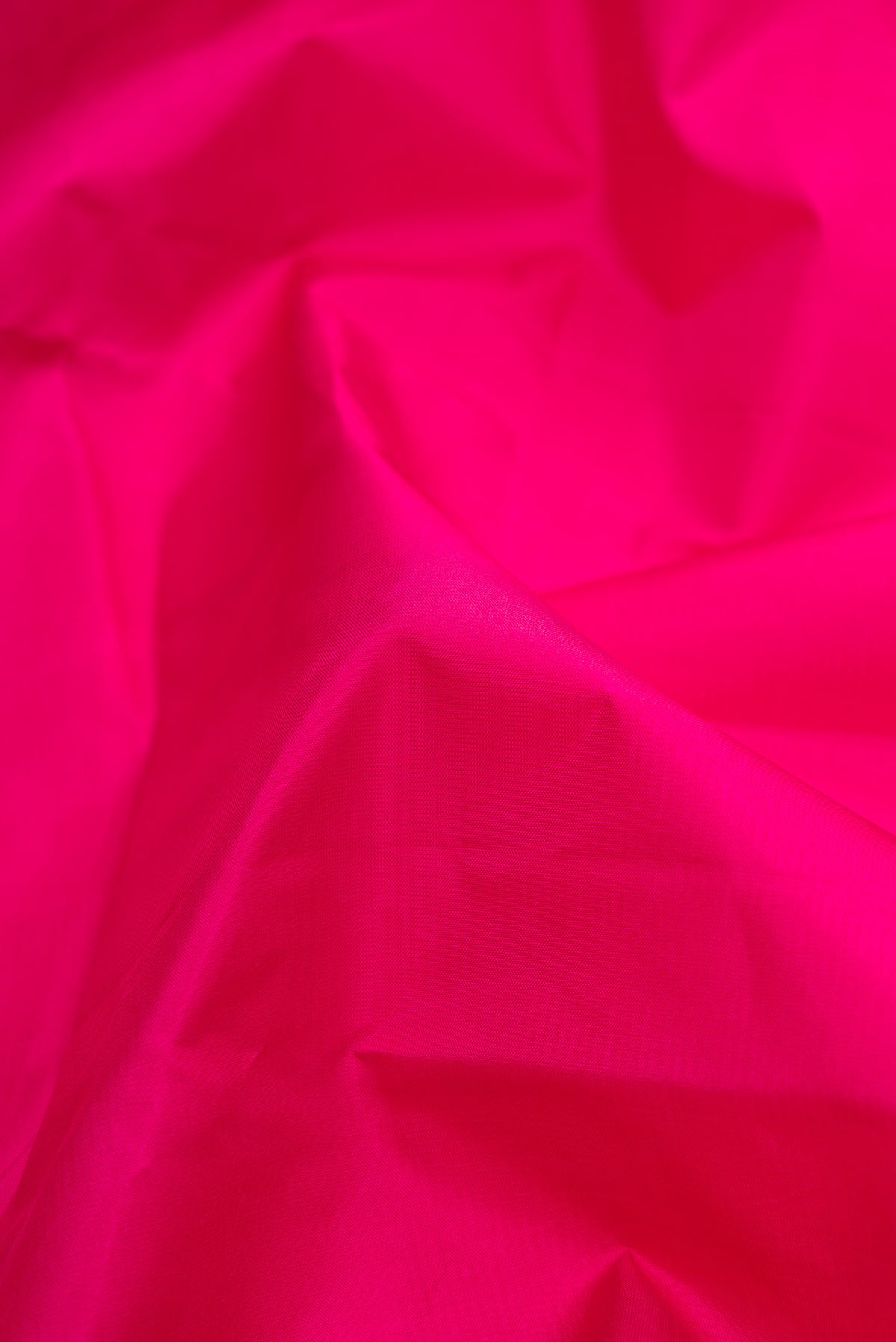 Close up of Magenta Dual Tone Kanjivaram Silk Saree with Plain Body and Zari Border.  displaying folds