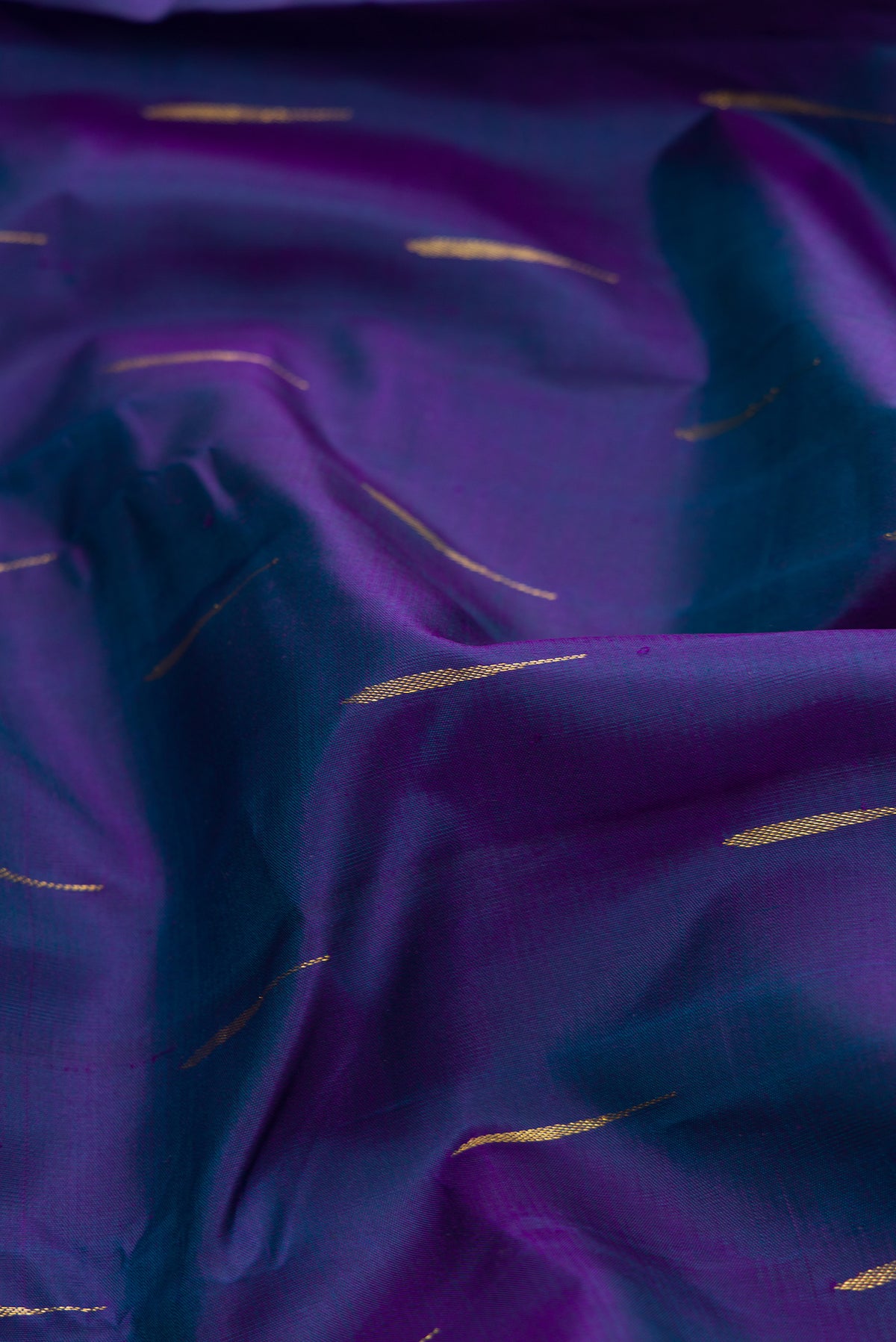 Close up of Peacock Blue Dual Tone Kanchipuram Silk Saree with Zari Butta on the body and Zari Border.  displaying folds