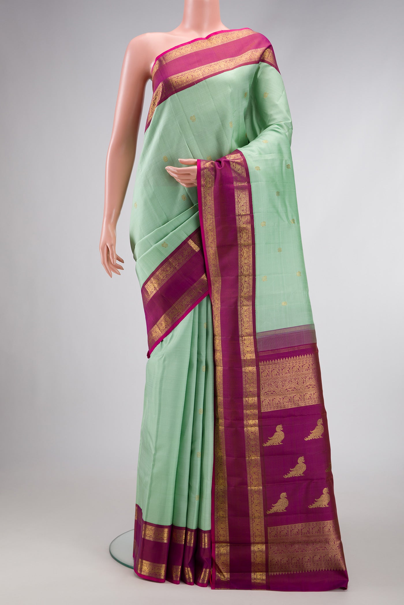 Pure Silk Pure Zari Light Green Dual Tone Kanjivaram Saree with Zari Butta on the body and Zari Border.  displayed on a mannequin