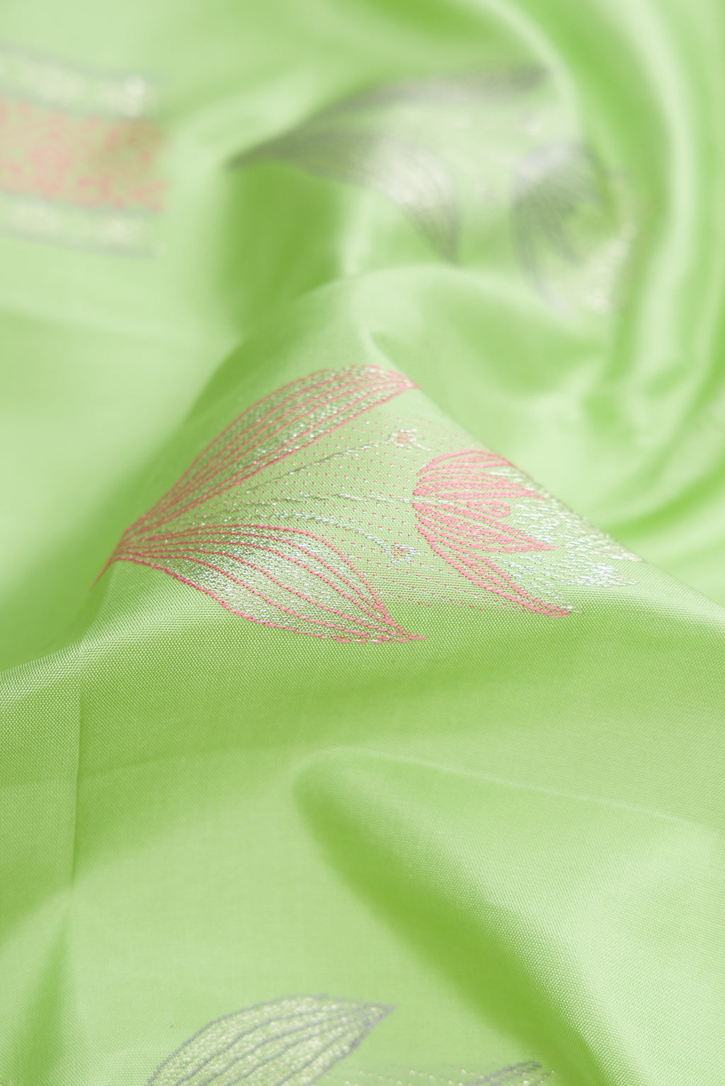 Close up of Pista Green Dual Tone Kanjivaram Silk Saree with Zari And Thread Butta on the body and Without Border.  displaying folds