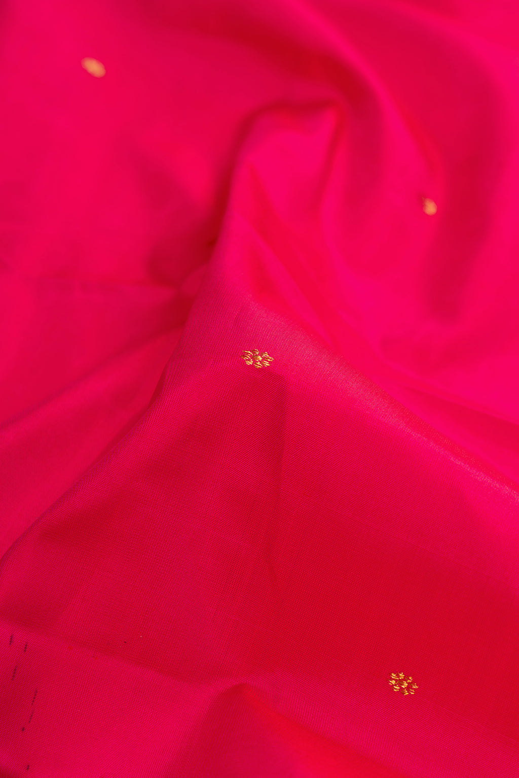 Close up of Dark Pink Dual Tone Kanchipuram Silk Saree with Zari Butta on the body and Zari Border.  displaying folds