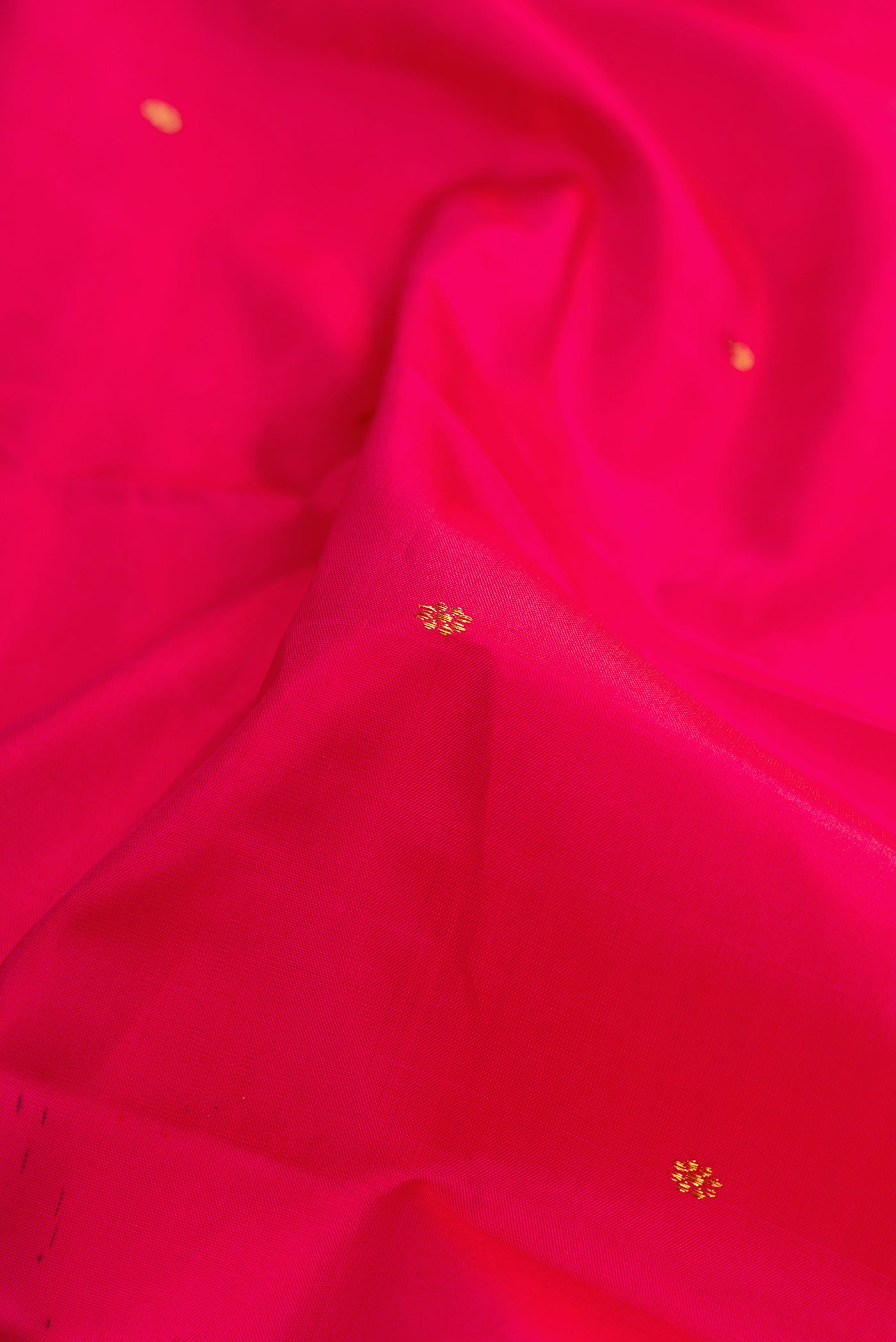 Close up of Dark Pink Dual Tone Kanchipuram Silk Saree with Zari Butta on the body and Zari Border.  displaying folds