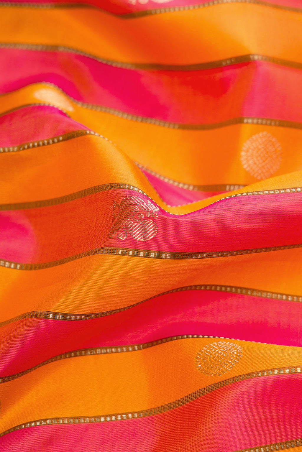 Close up of Orange and Pink Color Kanjivaram Silk Saree with Stripes on the body and Zari Border.  displaying folds