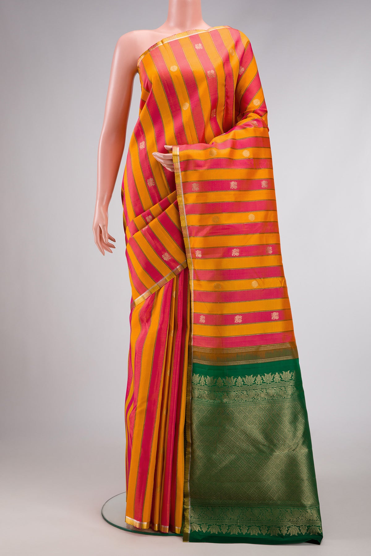 Orange and Pink Color Kanjivaram Silk Saree with Stripes on the body and Zari Border.  displayed on a mannequin