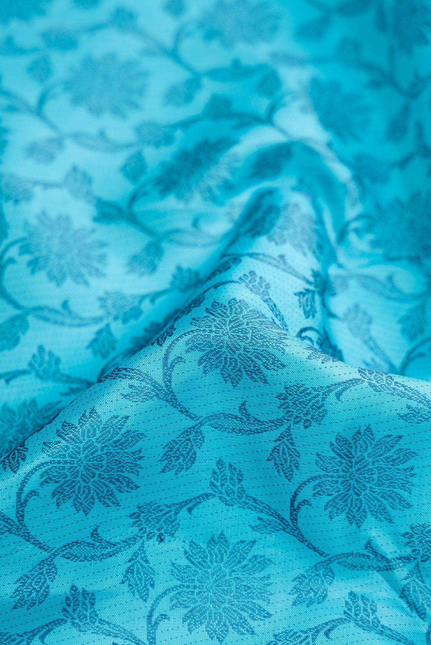 Close up of Sky Blue Dual Tone Kanjivaram Silk Saree with Zari Butta on the body and Fancy Border.  displaying folds